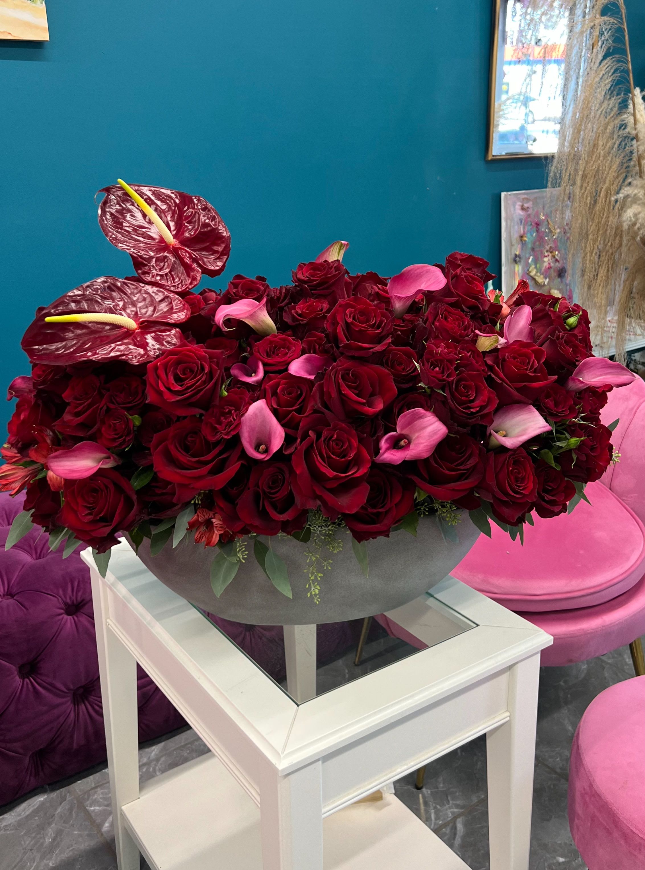 Red roses and pink calla lilies in a gray bowl centerpiece