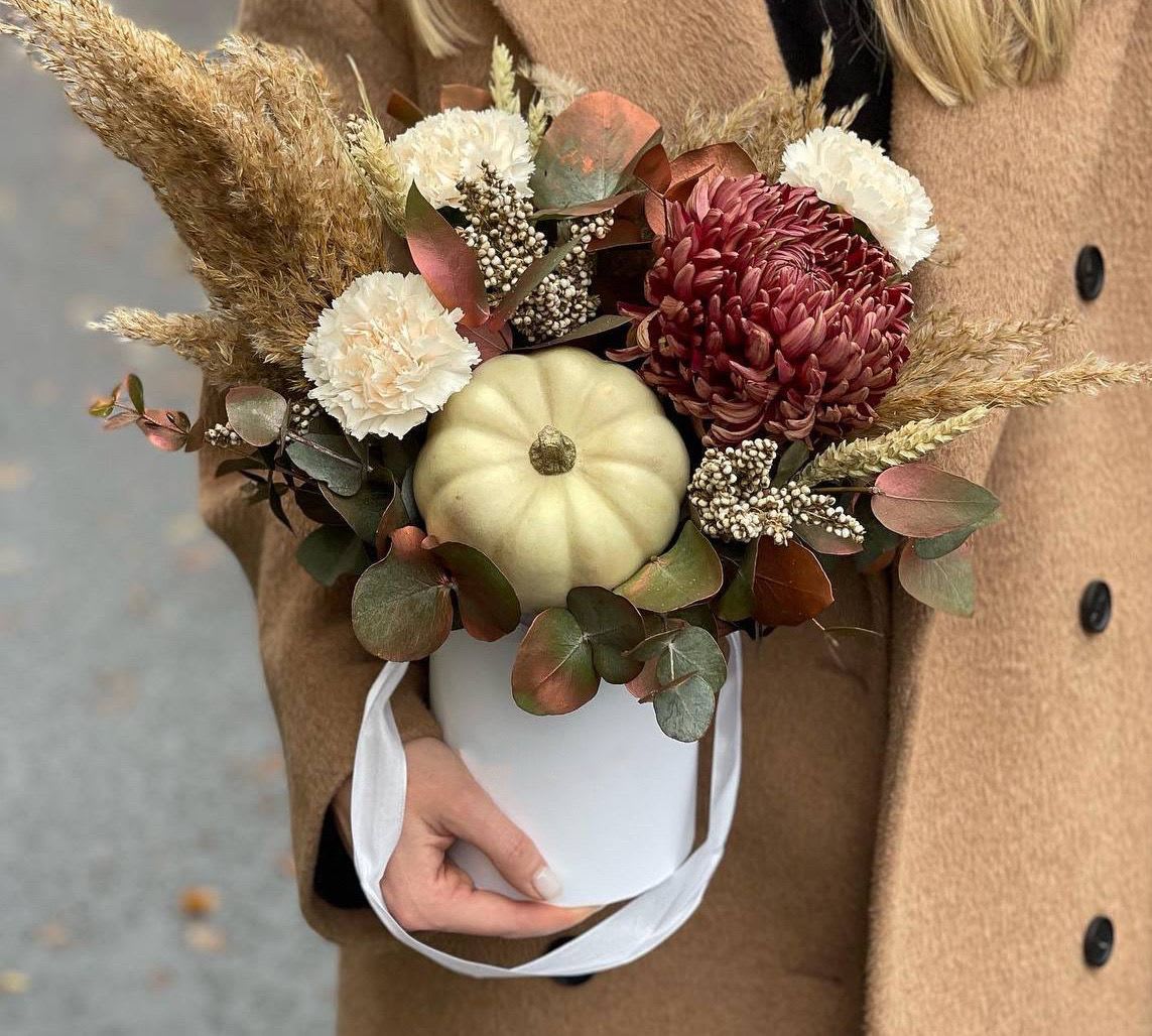 Autumn bouquet with chrysanthemums and a small pumpkin in a white bucket