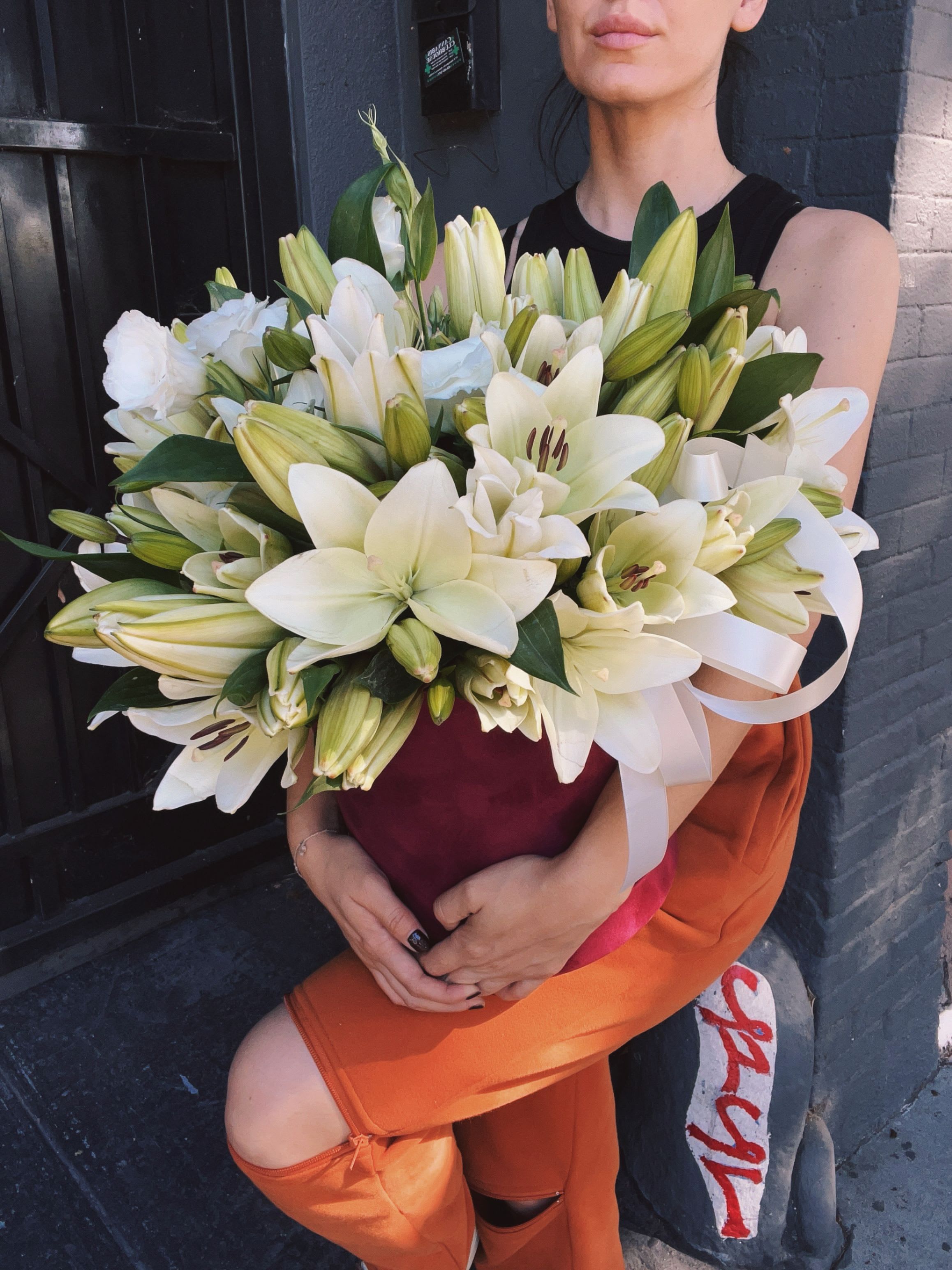 Large bouquet of white lilies held by a person