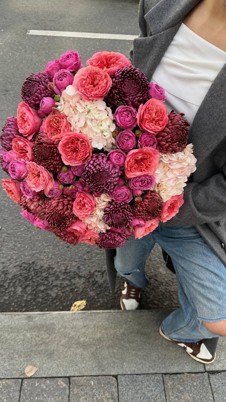 Large bouquet of pink and burgundy flowers with white hydrangea clusters