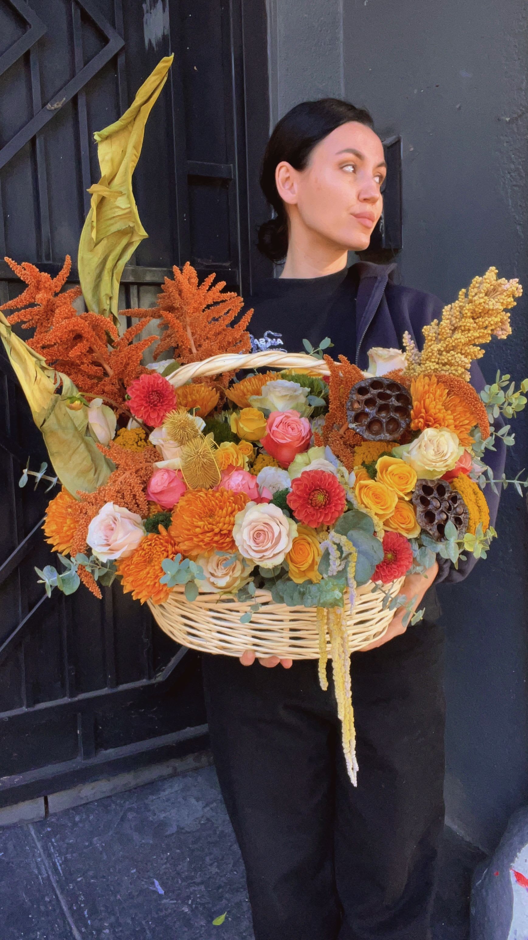Large basket of orange, yellow, pink, and white flowers