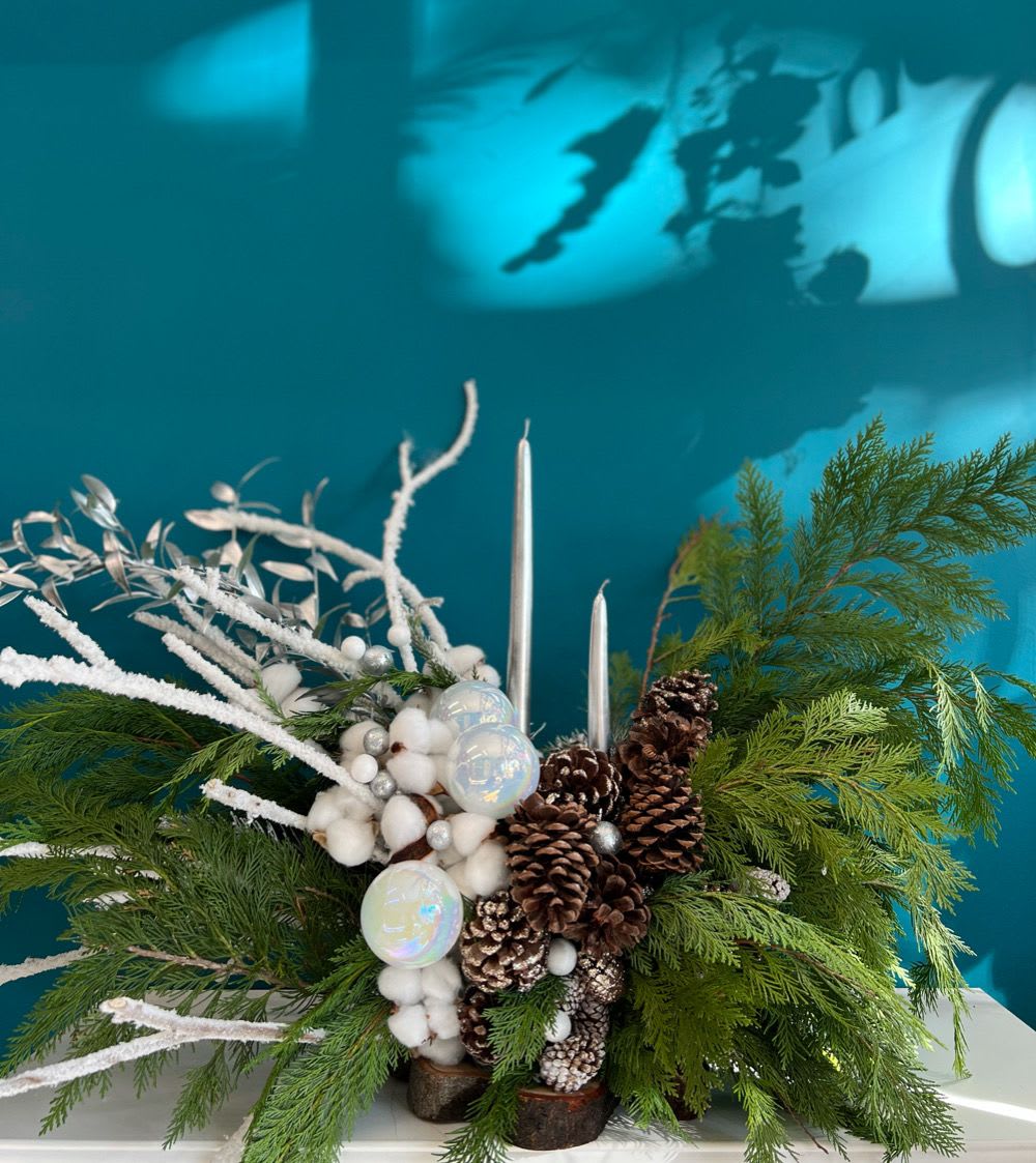 Winter centerpiece with pinecones, white accents, and silver candles