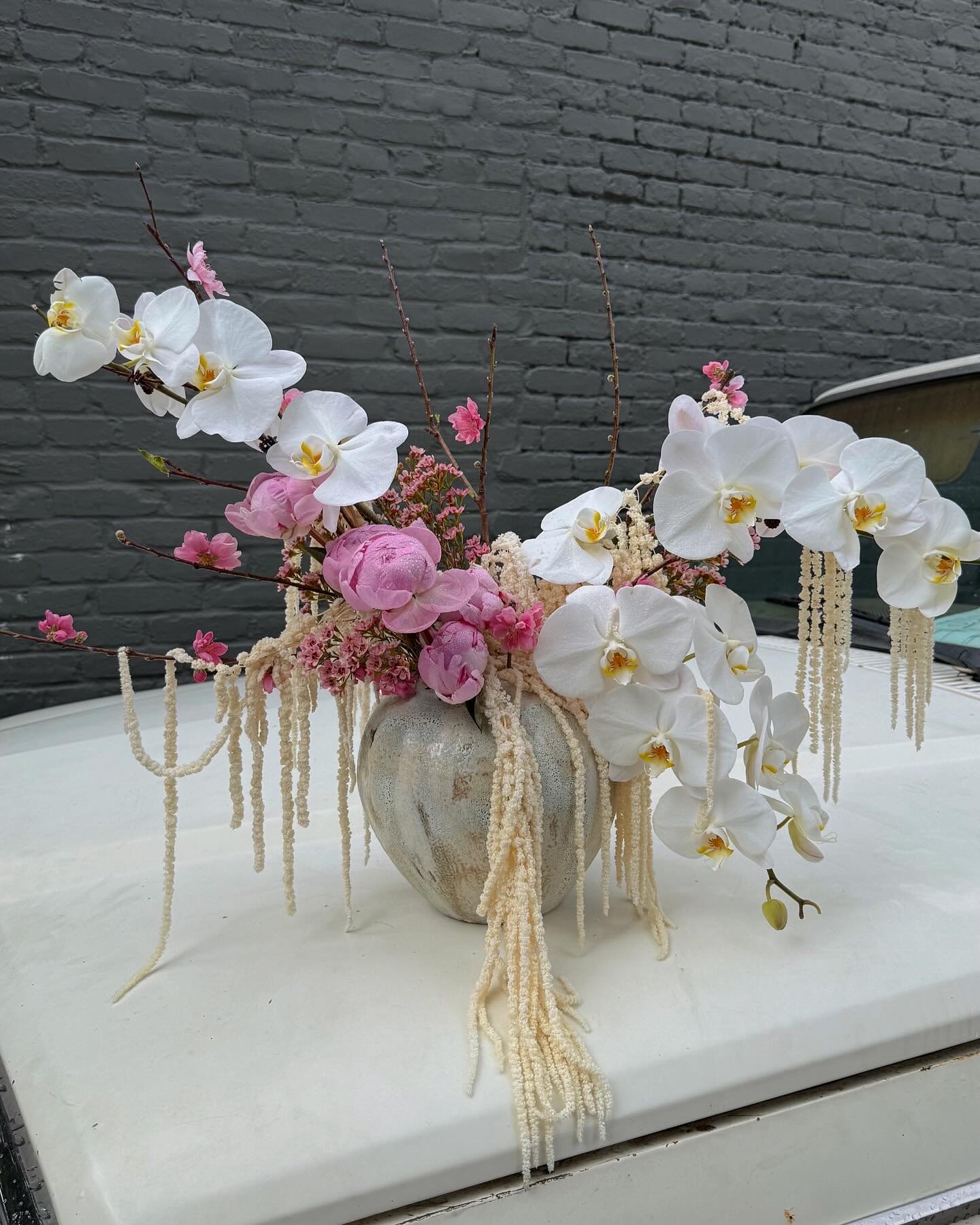 Pink and white orchid arrangement in a ceramic vase