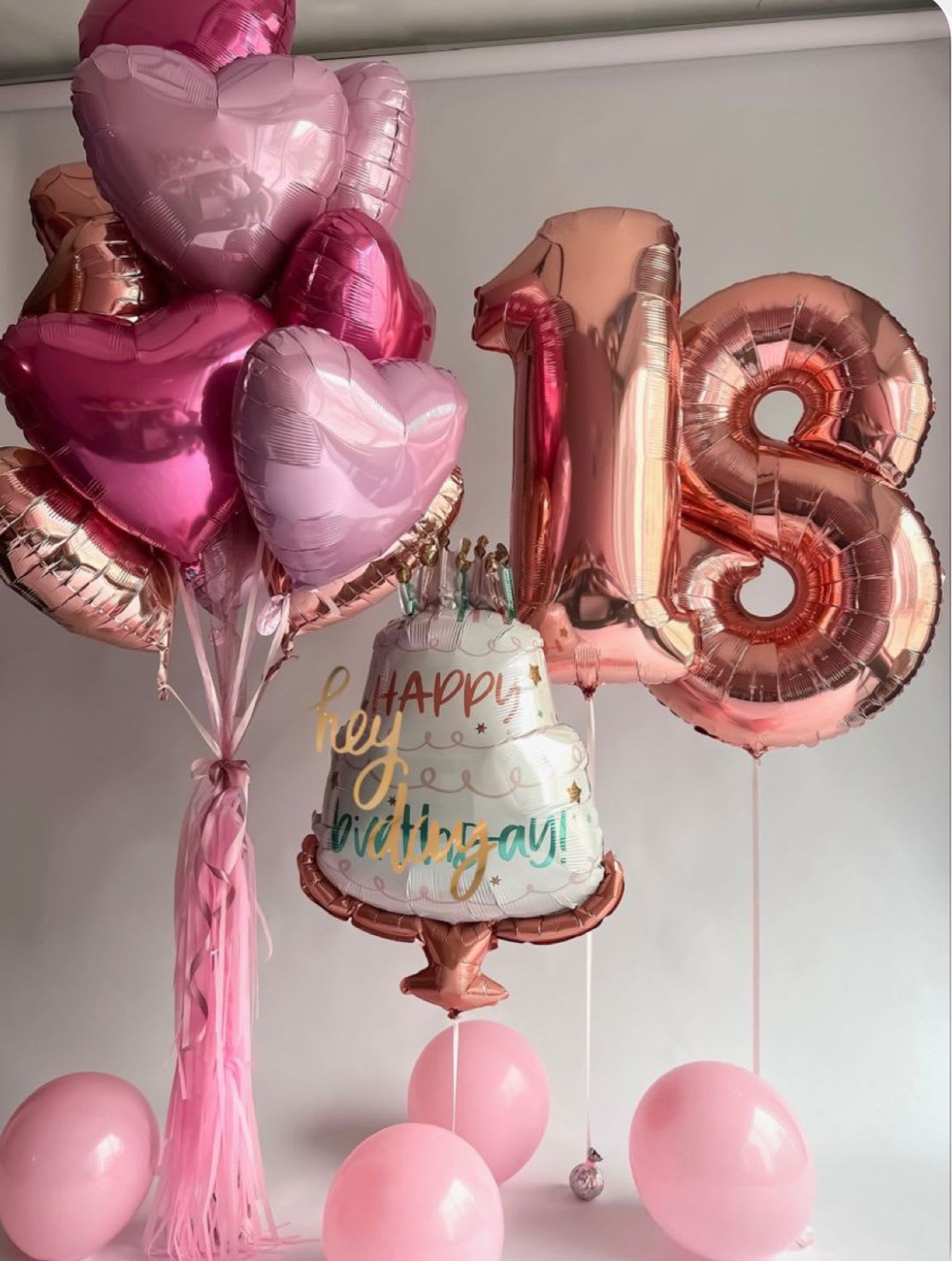 Pink heart balloons and a rose-gold 18 birthday balloon with a cake balloon