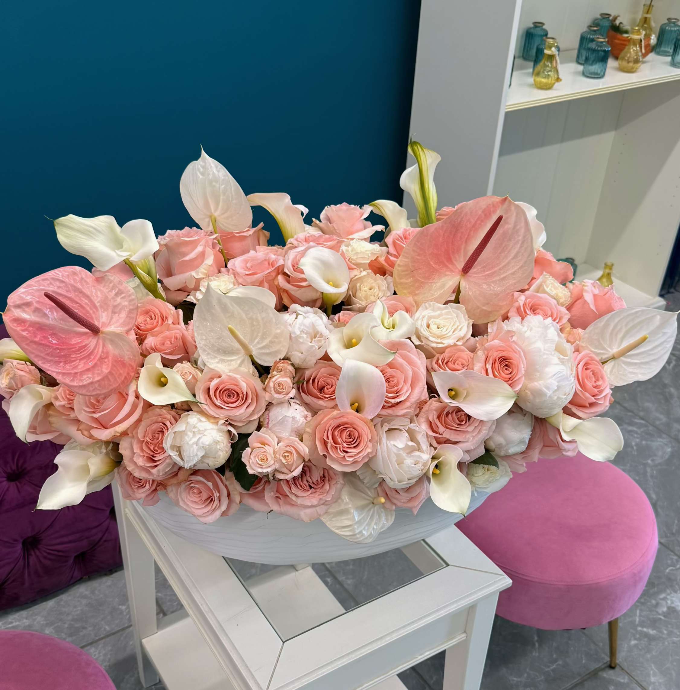 Large pastel bouquet of pink roses and white calla lilies in a white bowl
