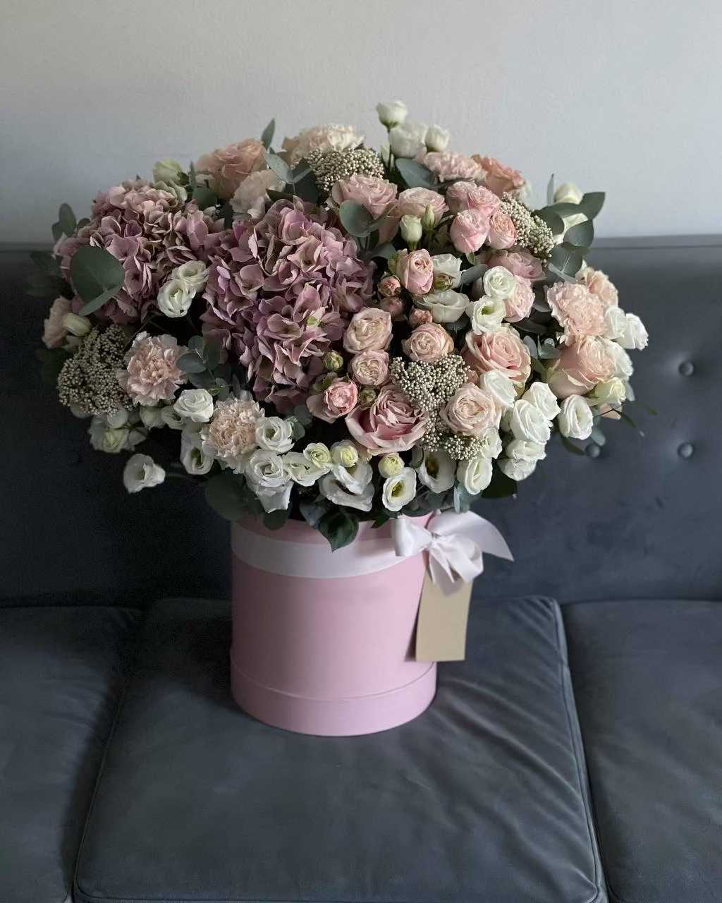 Pink and white bouquet in a round pink hat box