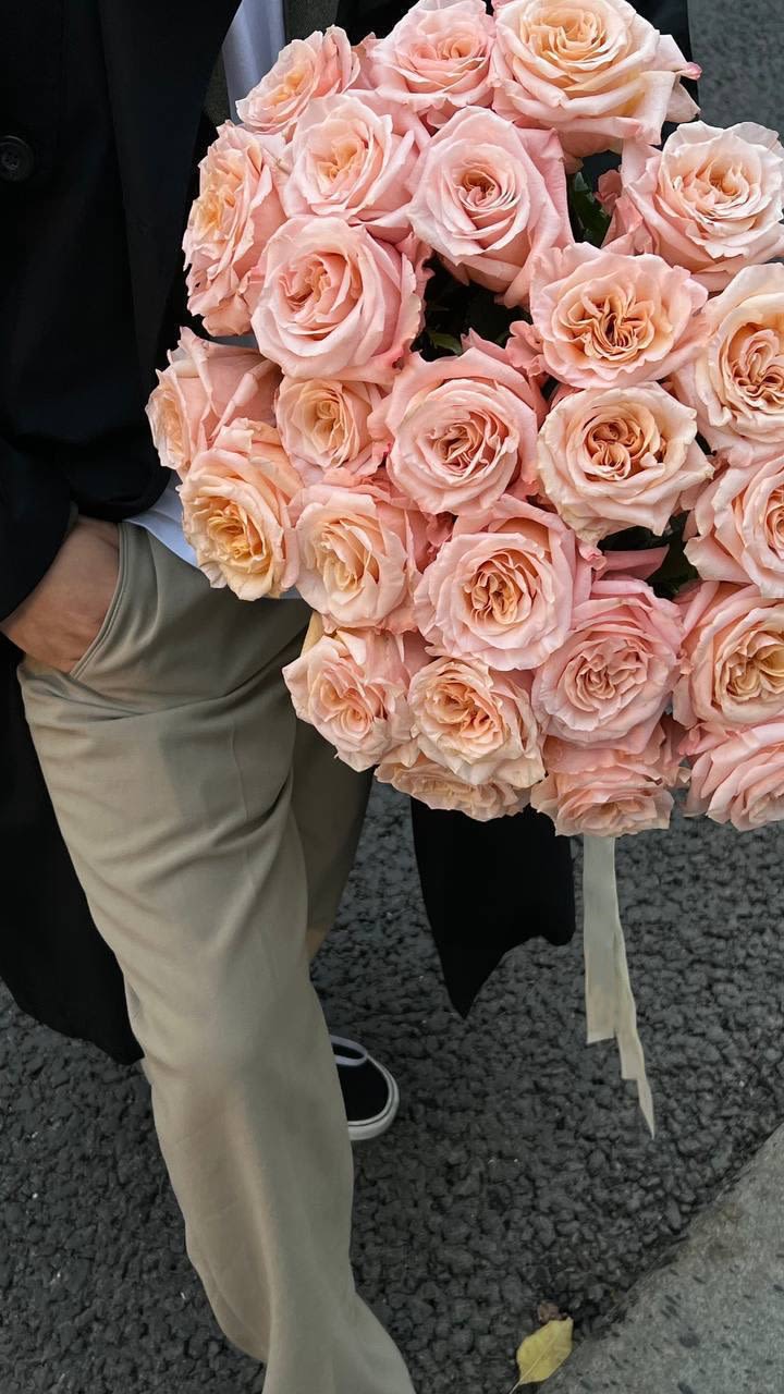Large bouquet of pale pink roses held by a person