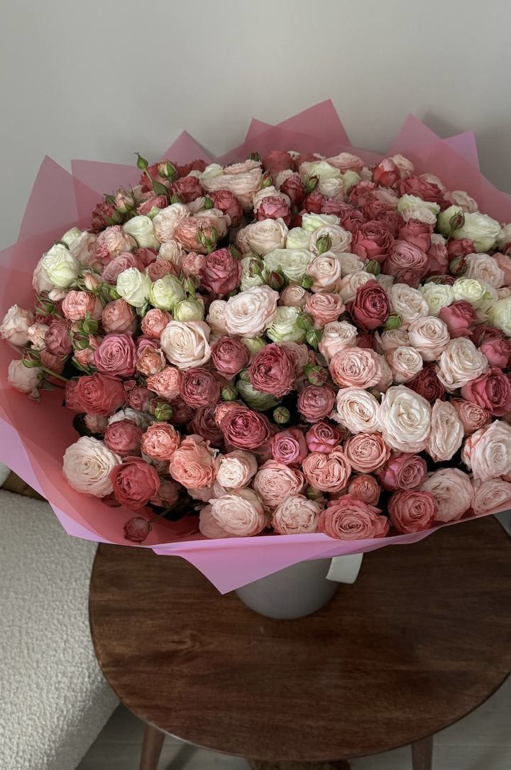 Large bouquet of pink and white roses wrapped in pink paper