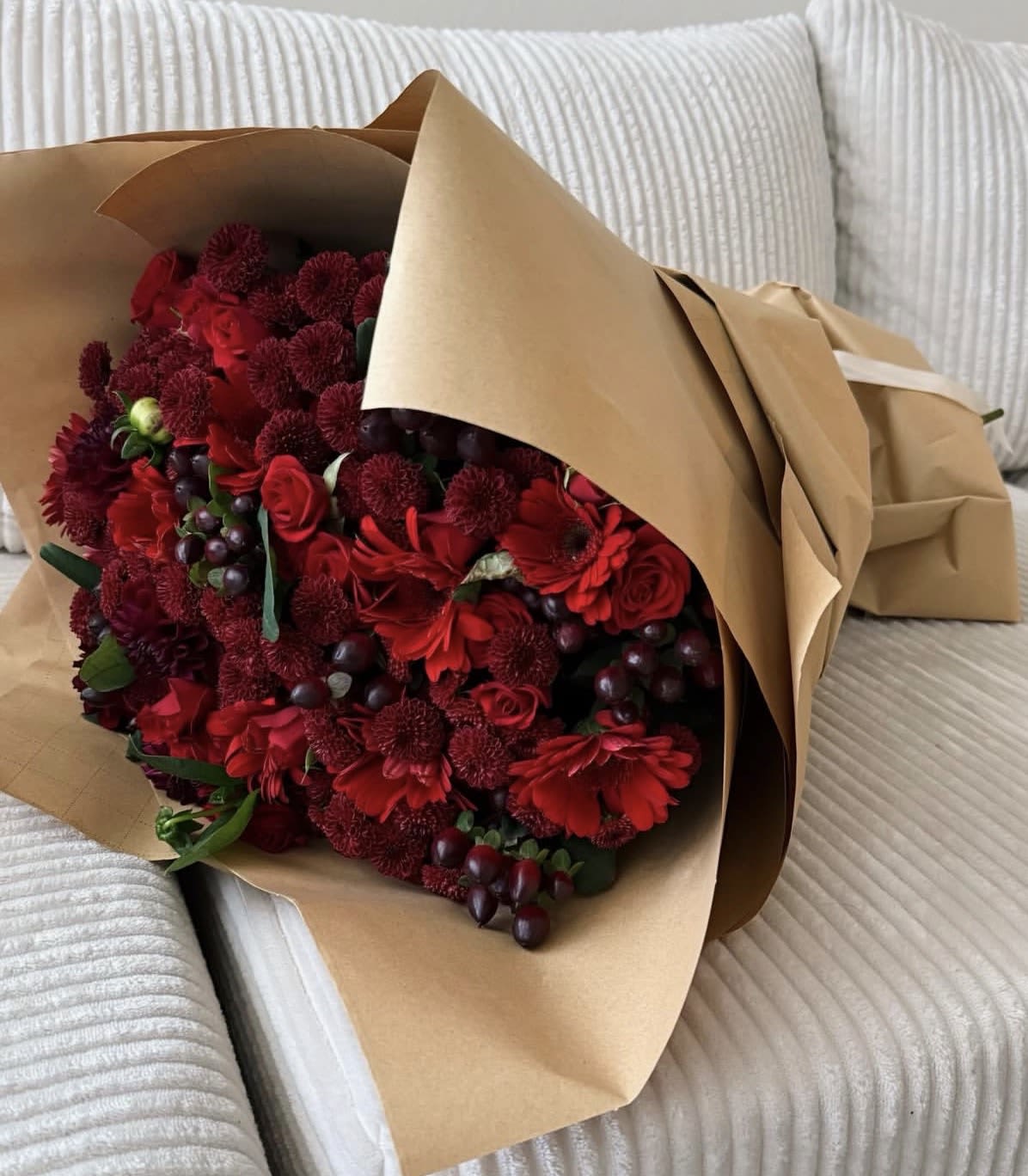 Bouquet of red flowers wrapped in brown paper