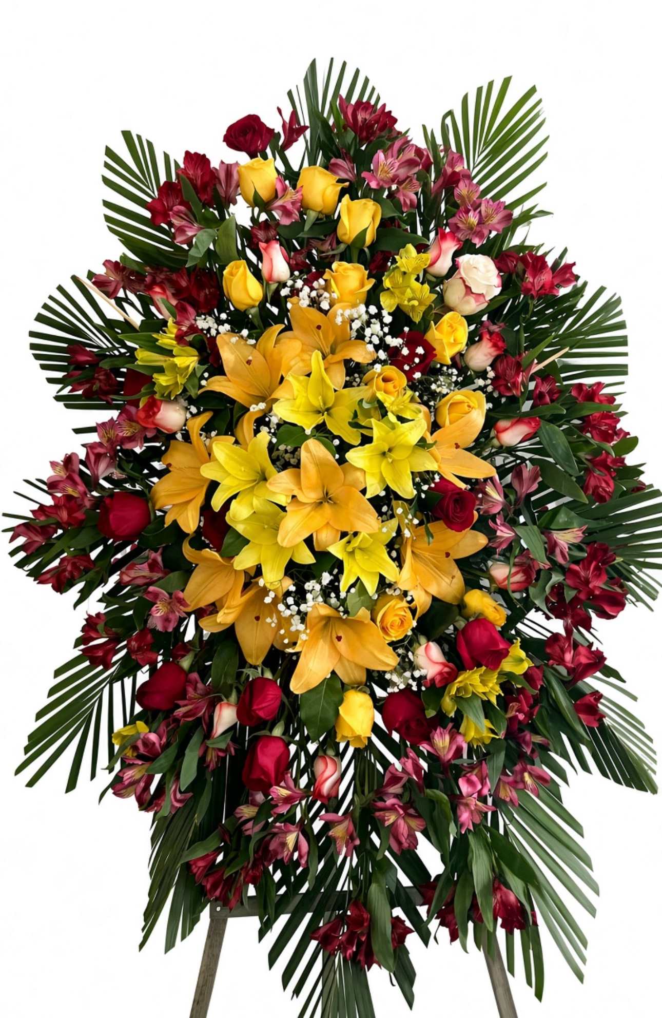 Large standing floral spray with yellow lilies, red roses, and pink blooms