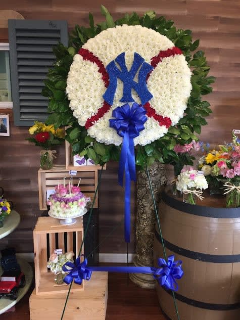 Large floral baseball wreath with a blue Yankees logo and ribbon
