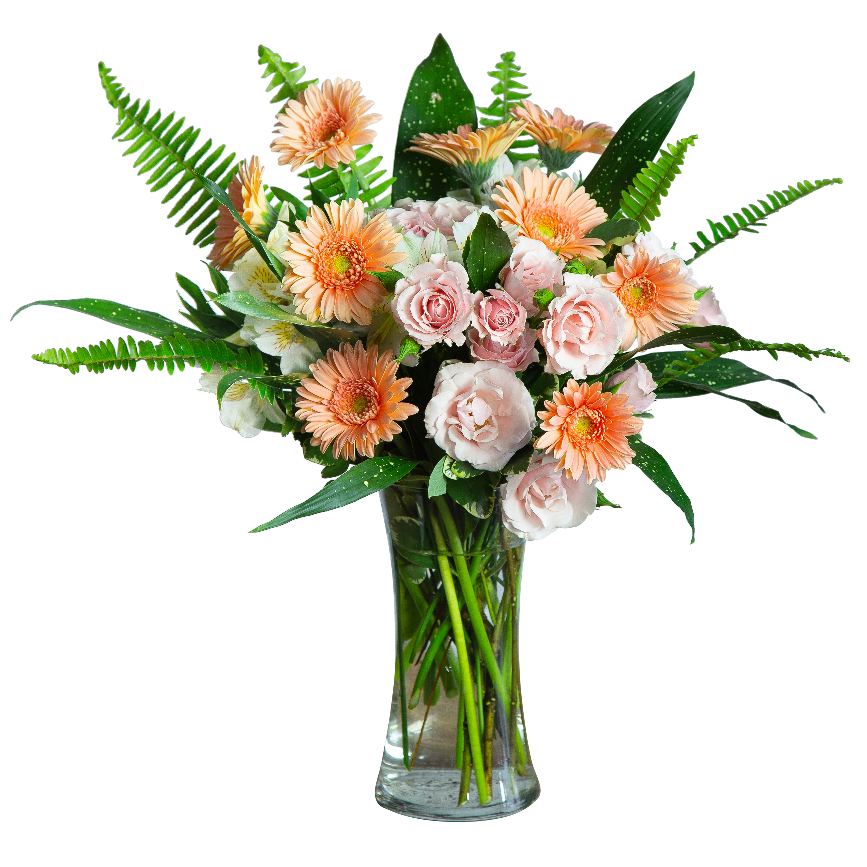 Peach gerbera daisies and pale pink roses in a clear glass vase