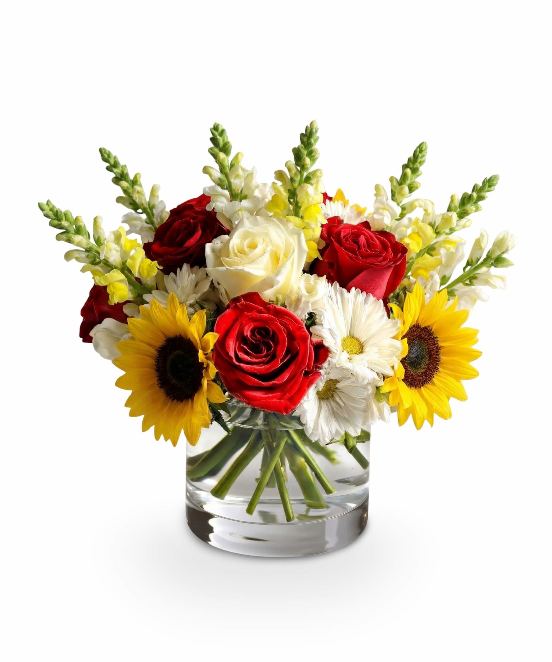 Sunshine Whirl - Like a summer breeze that carries laughter and warmth, Sunshine Whirl is a joyful swirl of color and cheer. Vibrant red and creamy white roses meet golden sunflowers and crisp white daisies, creating a radiant display that channels the carefree spirit of sunny days and backyard celebrations. Nestled in a clear glass vase, this arrangement is perfect for brightening any room or making someone’s summer day unforgettable.