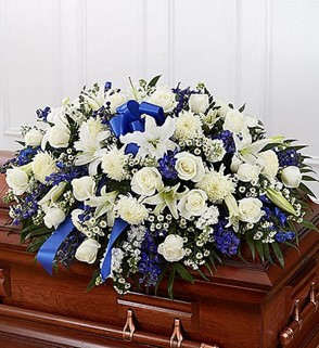 White and blue funeral spray on a casket with a blue ribbon