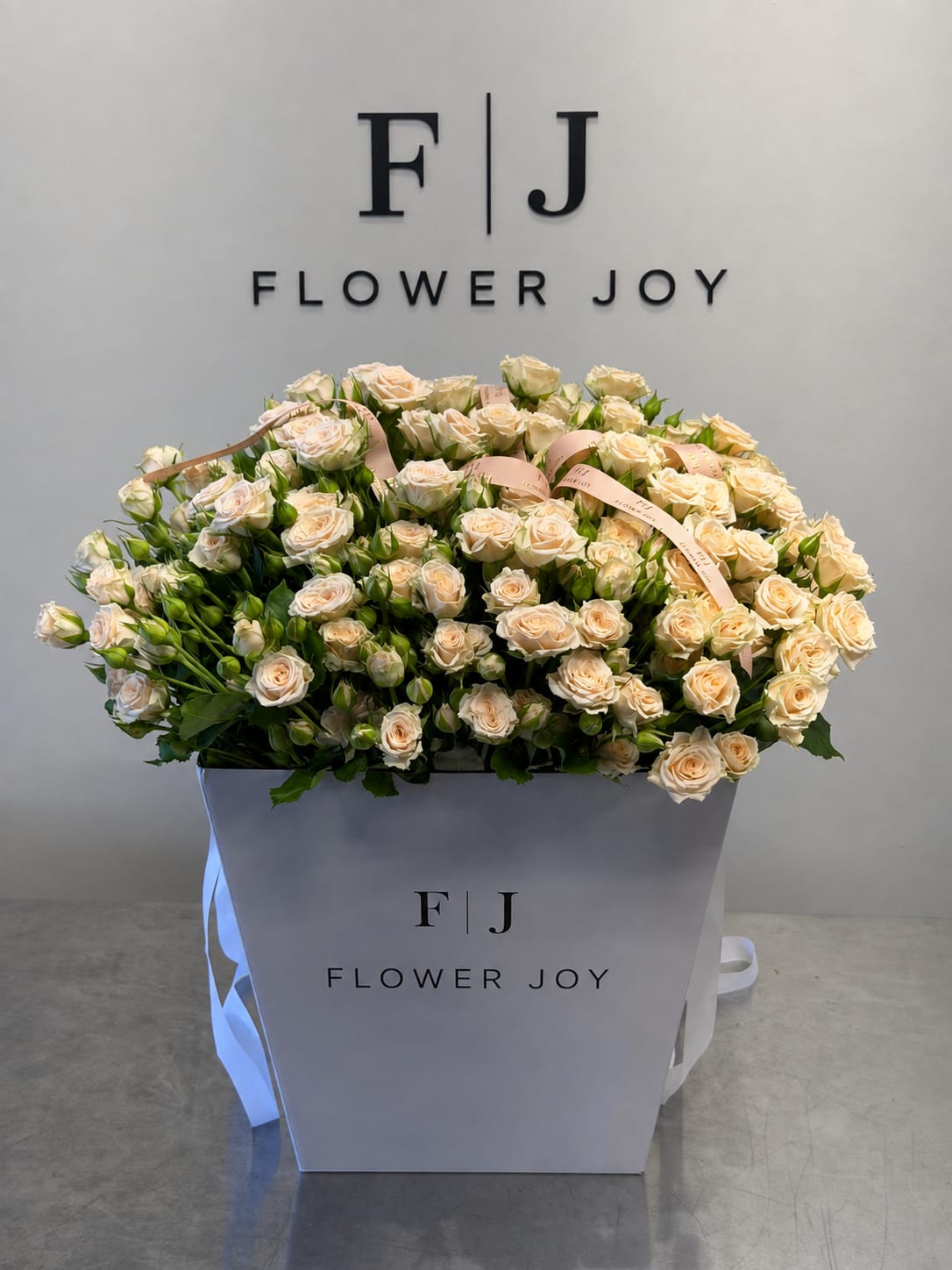 Large bouquet of cream spray roses in a white gift box