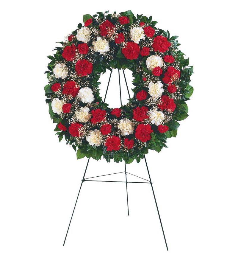 Round standing wreath of red and white carnations on a metal easel