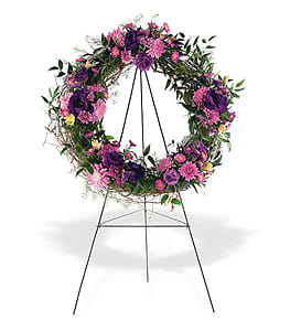 Standing wreath of purple and pink flowers on a metal easel