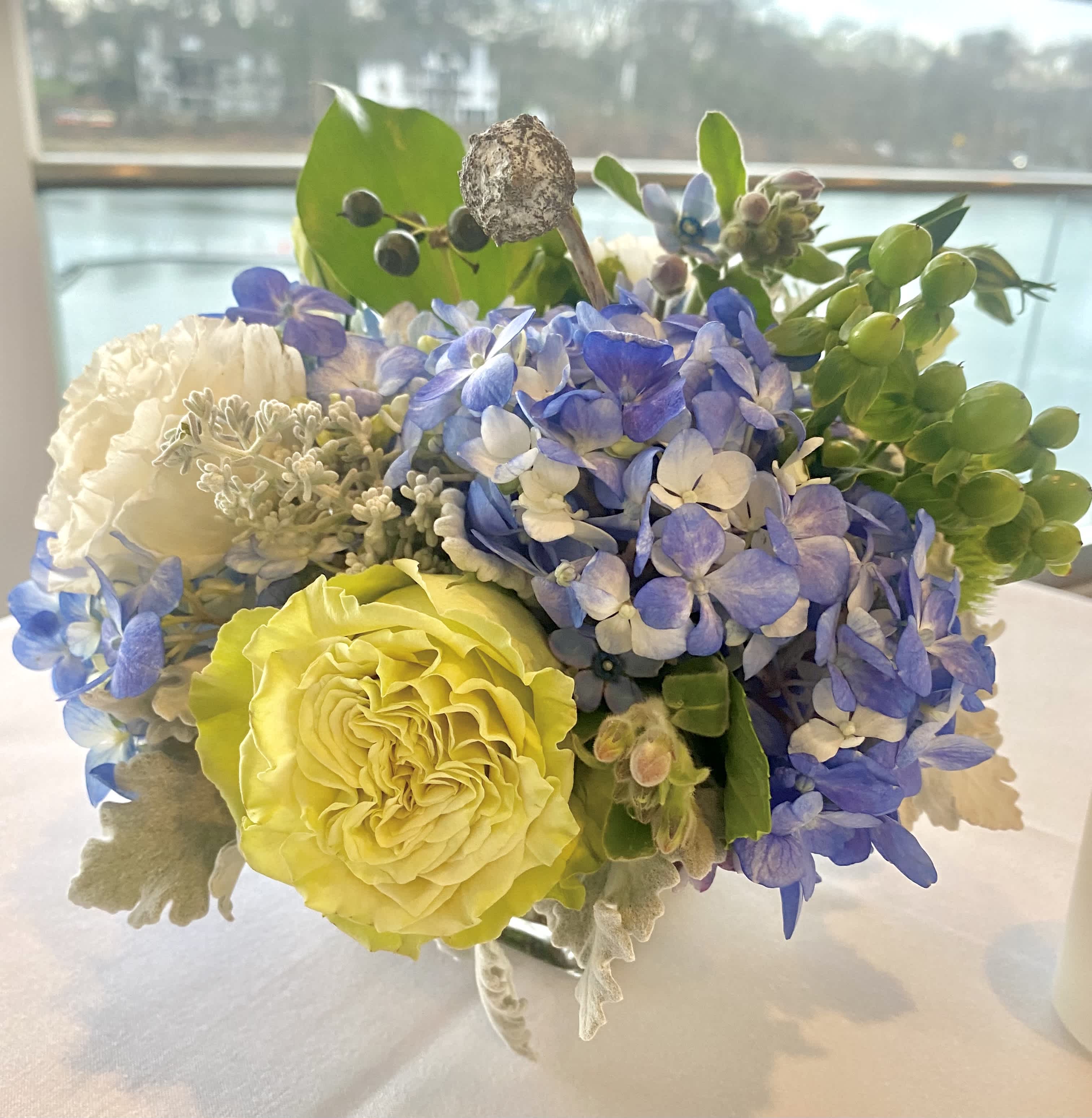 Bouquet of blue hydrangea, yellow rose, and white blooms