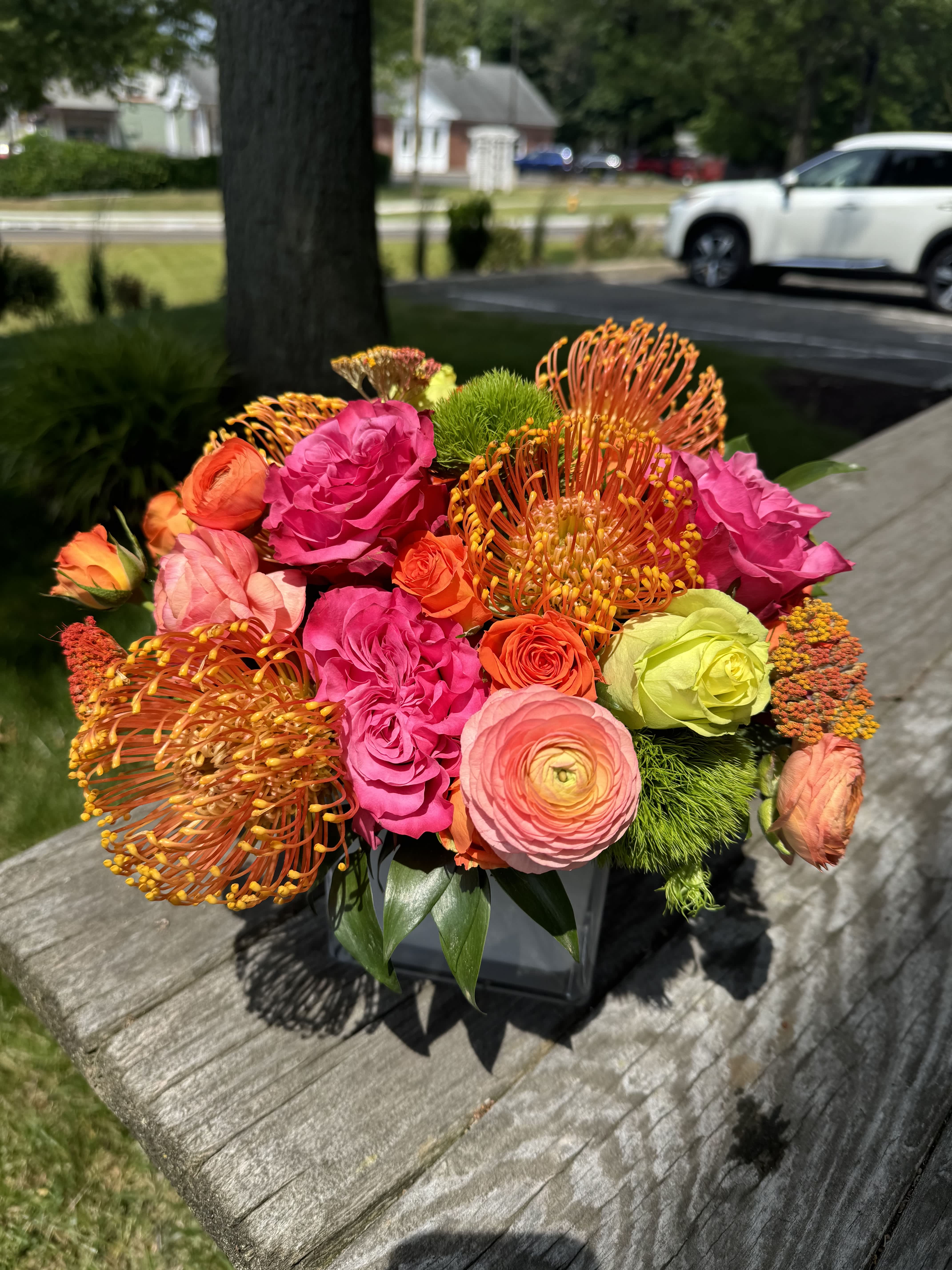 Bright mixed bouquet of pink, orange, and green flowers in a vase