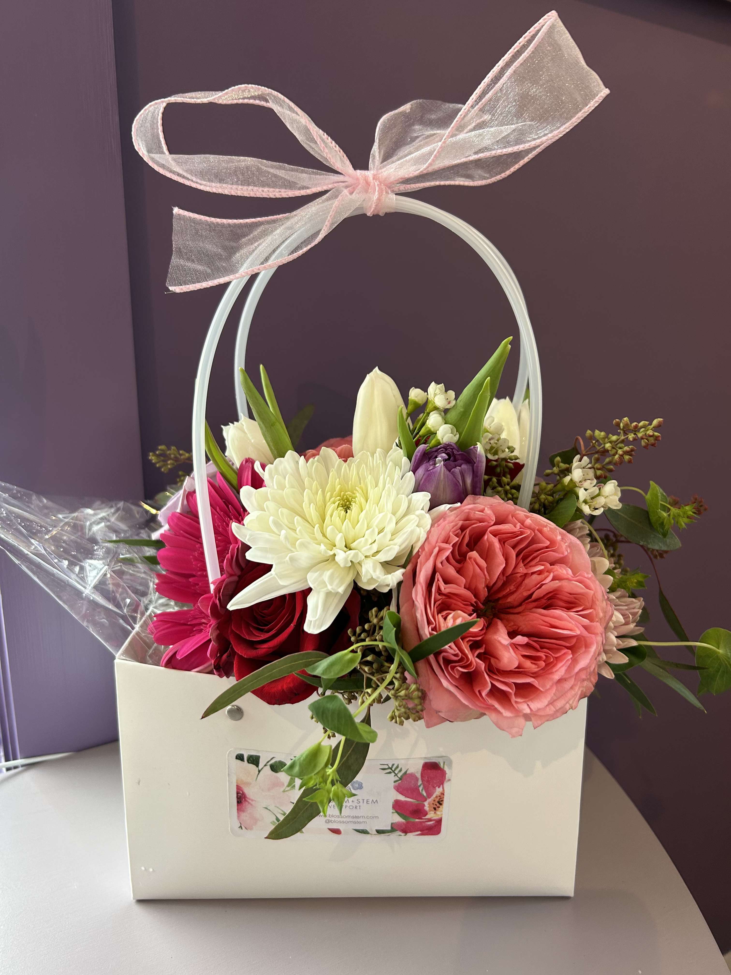 Mixed flower arrangement in a white gift box with a pink ribbon bow