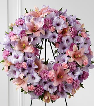 Lavender and pink floral wreath on a black stand