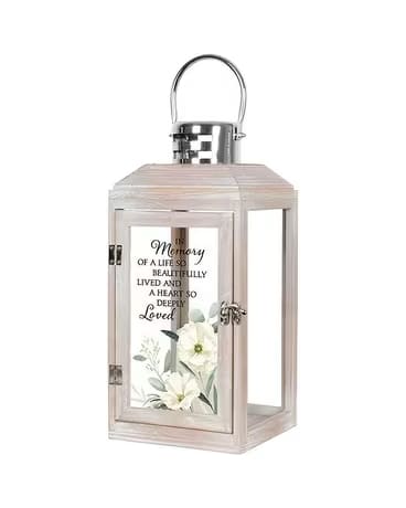 Decorative memorial lantern with white flowers and a printed tribute message