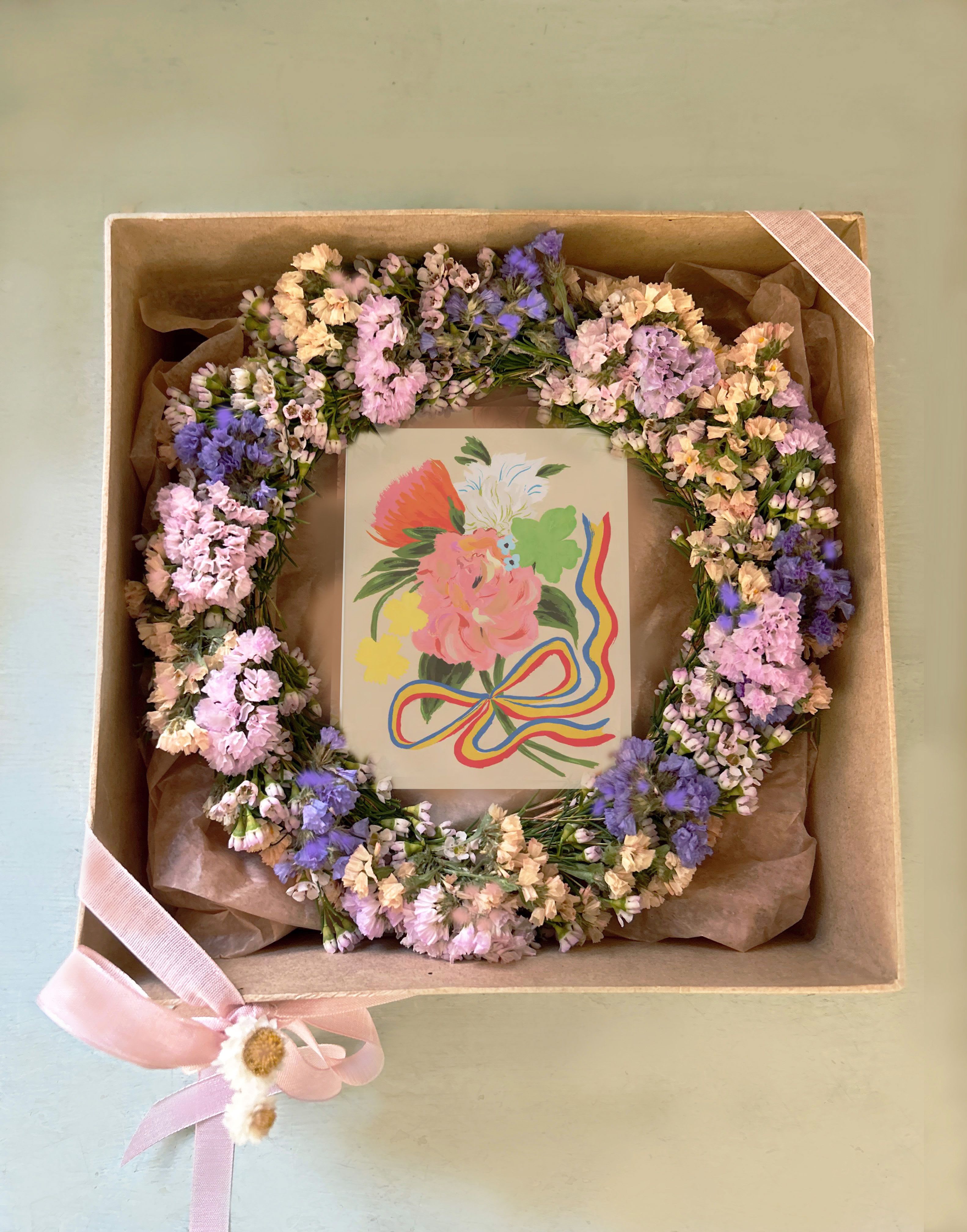 Forever Wreath in box - A lovely forever wreath made of natural dried flowers. The wreath is hand tied using pretty dried flowers in the colors of la: dusty blue, dusty peach, lavender, light pink and a hint of light brown.  The wreath is placed in a reusable paper box tied with riboon - a card is placed in the box, where the personal note for the recipient will be written. The wreath measure 10" - the box measures 10" by 10" by 5"  A gorgeous present, perfect for all occasions. Ready for daily LA delivery. We ship this box nationwide at www.blomstlosangeles.com