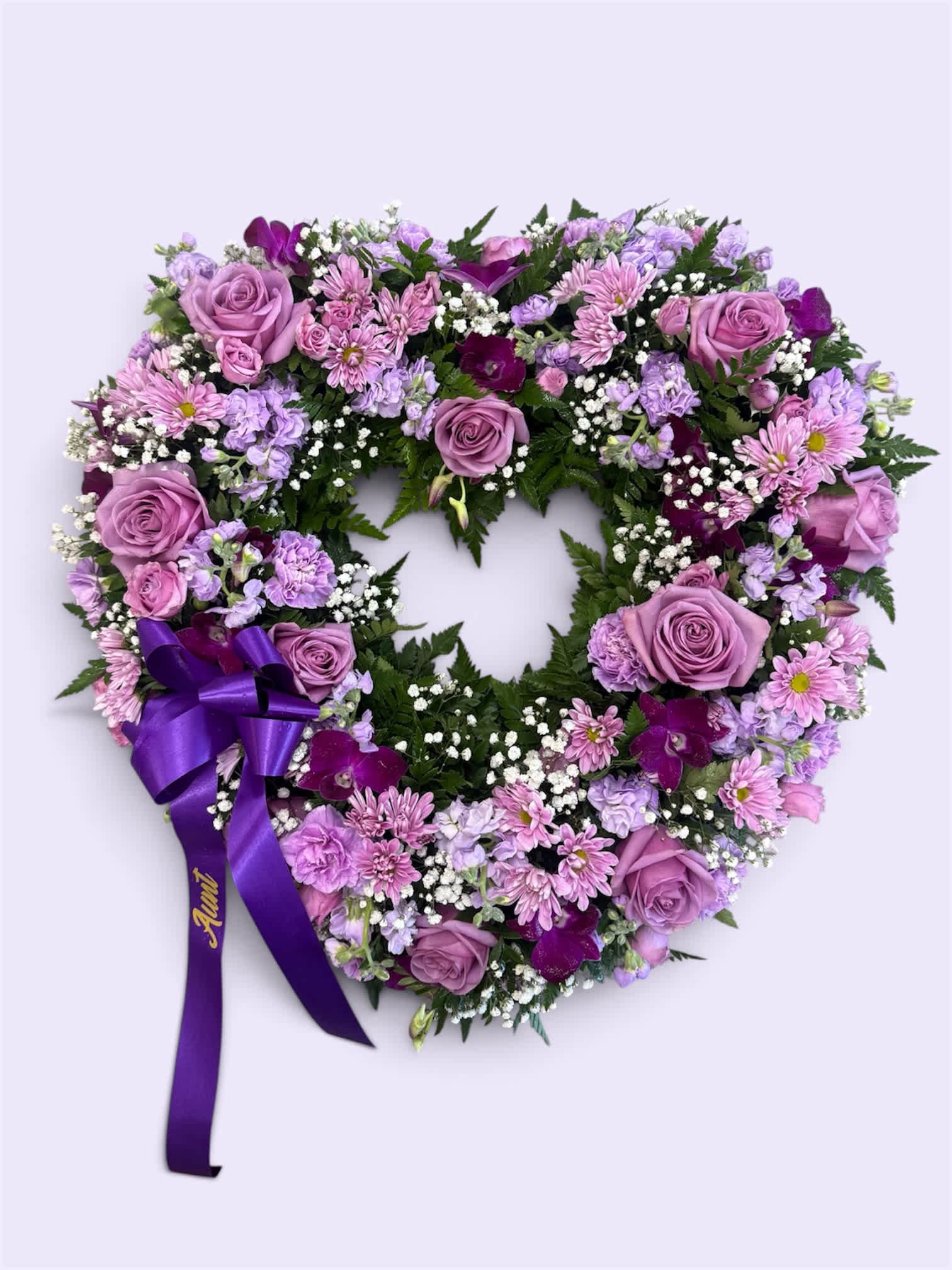 Heart-shaped floral wreath with lavender roses and purple ribbon