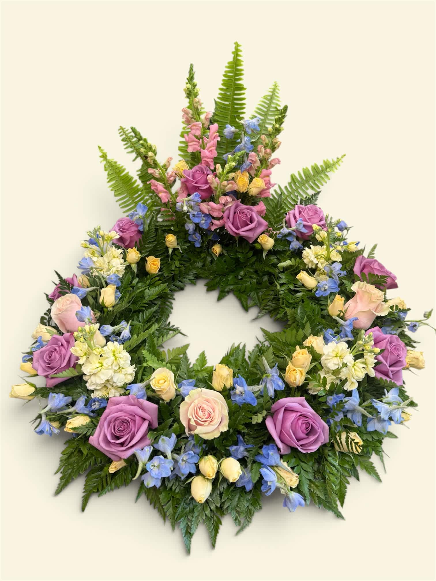Circular floral wreath with purple and pink roses and blue flowers