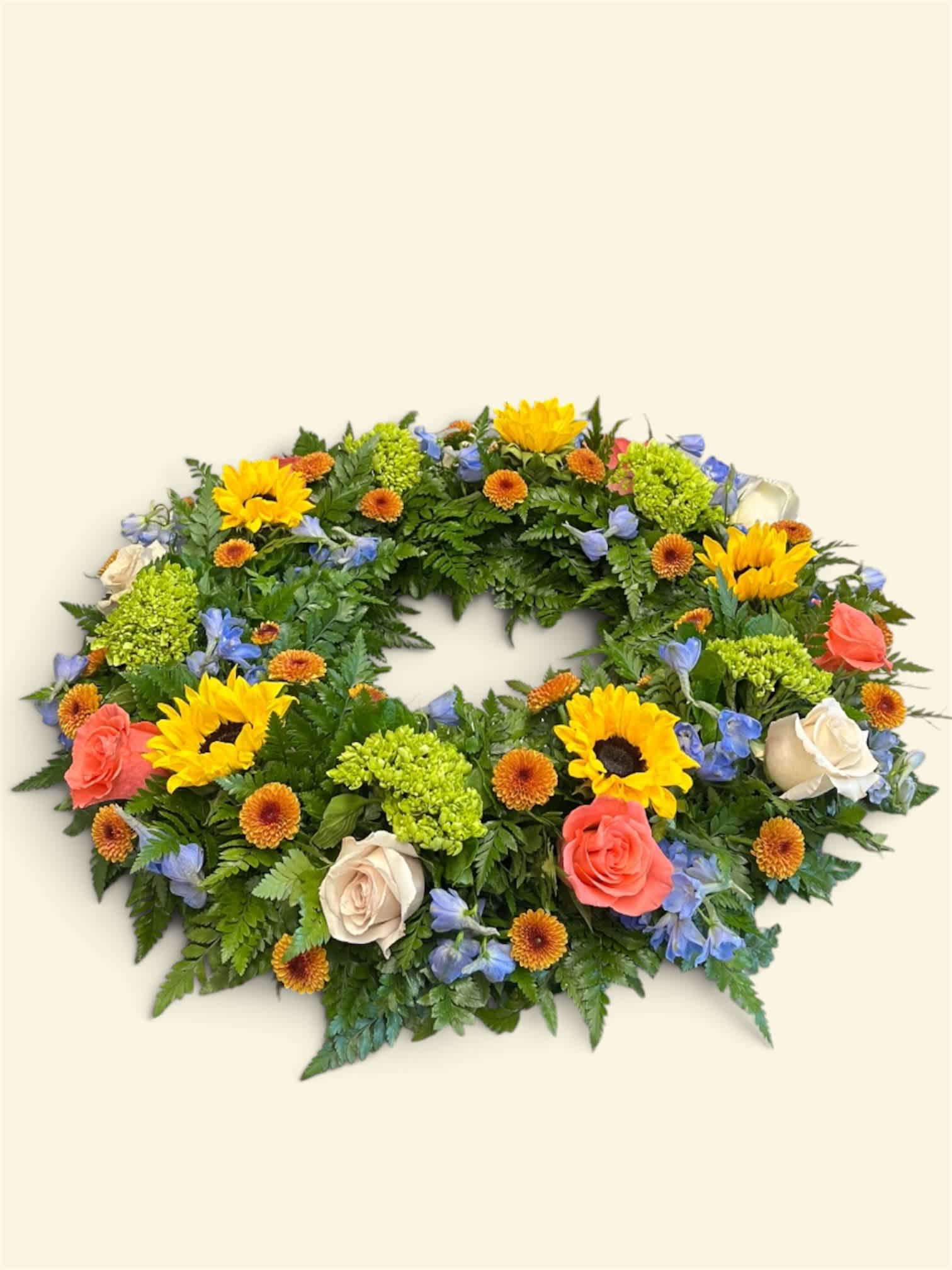 Oval floral wreath with sunflowers, roses, and blue flowers