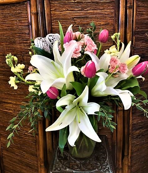 Bouquet of white lilies and pink tulips in a glass vase
