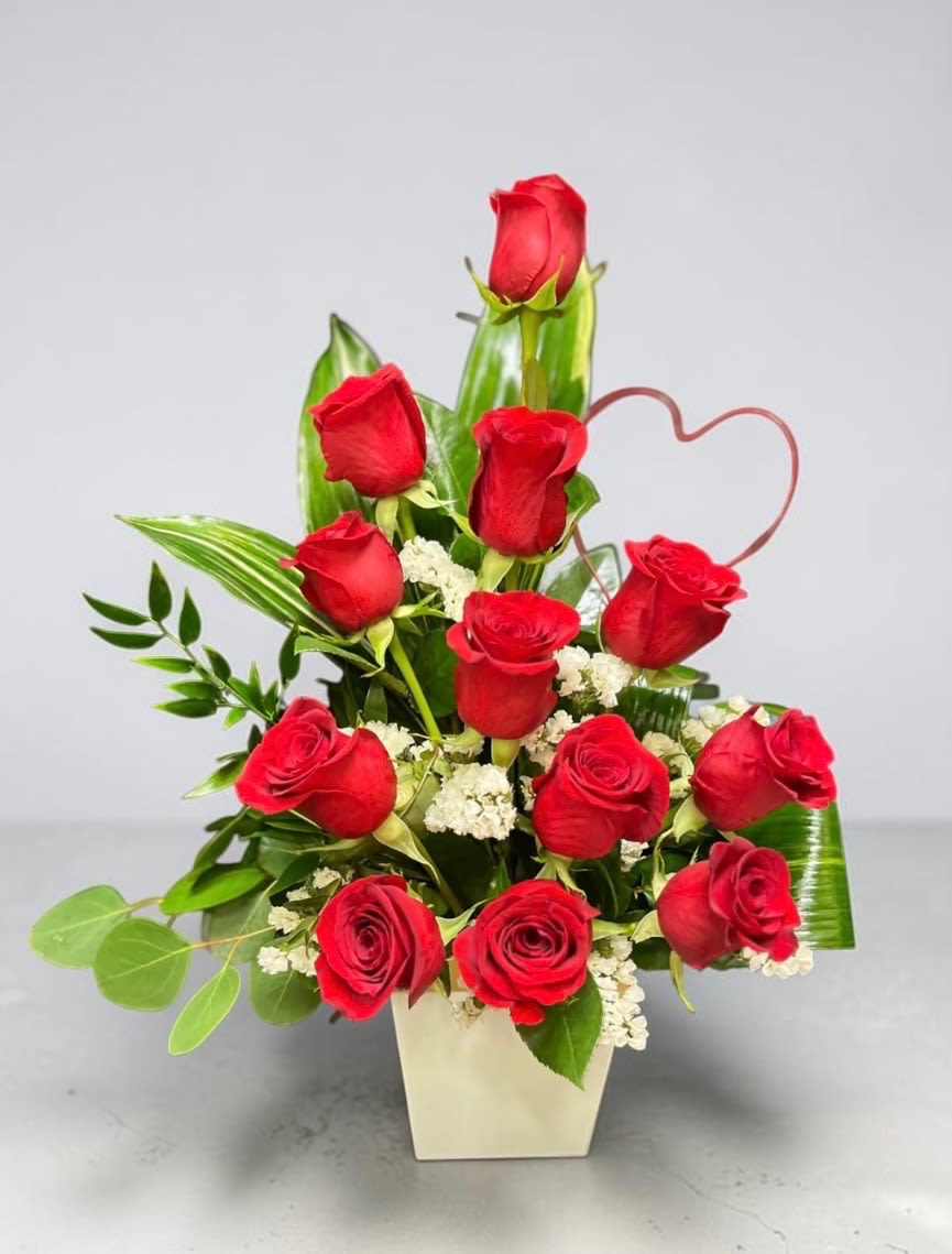 Rose's with a twist - Nothing says love more than a unique dozen red roses designed in a resin cube. Container may vary.