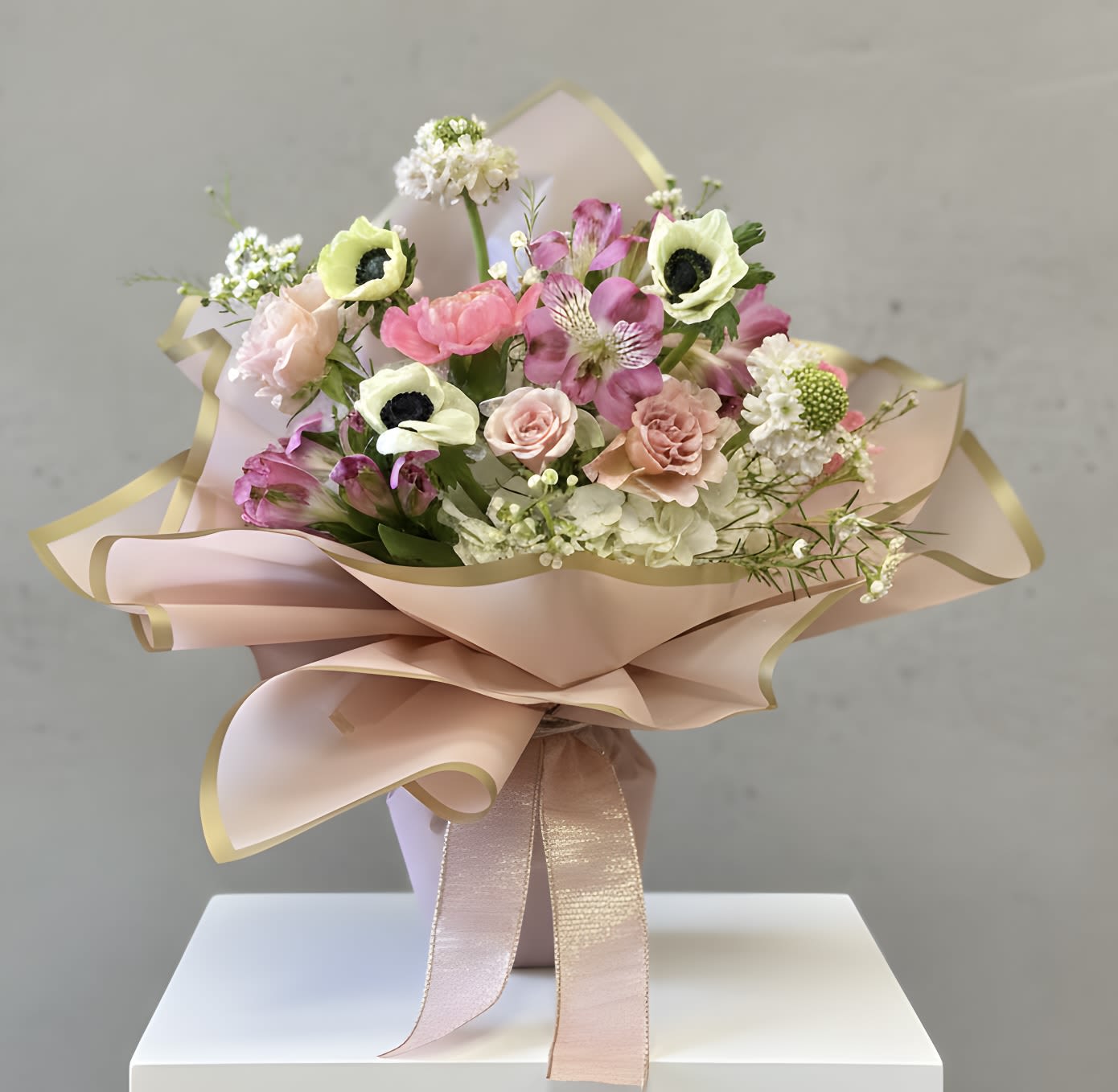 Bouquet of pink and white flowers wrapped in blush paper