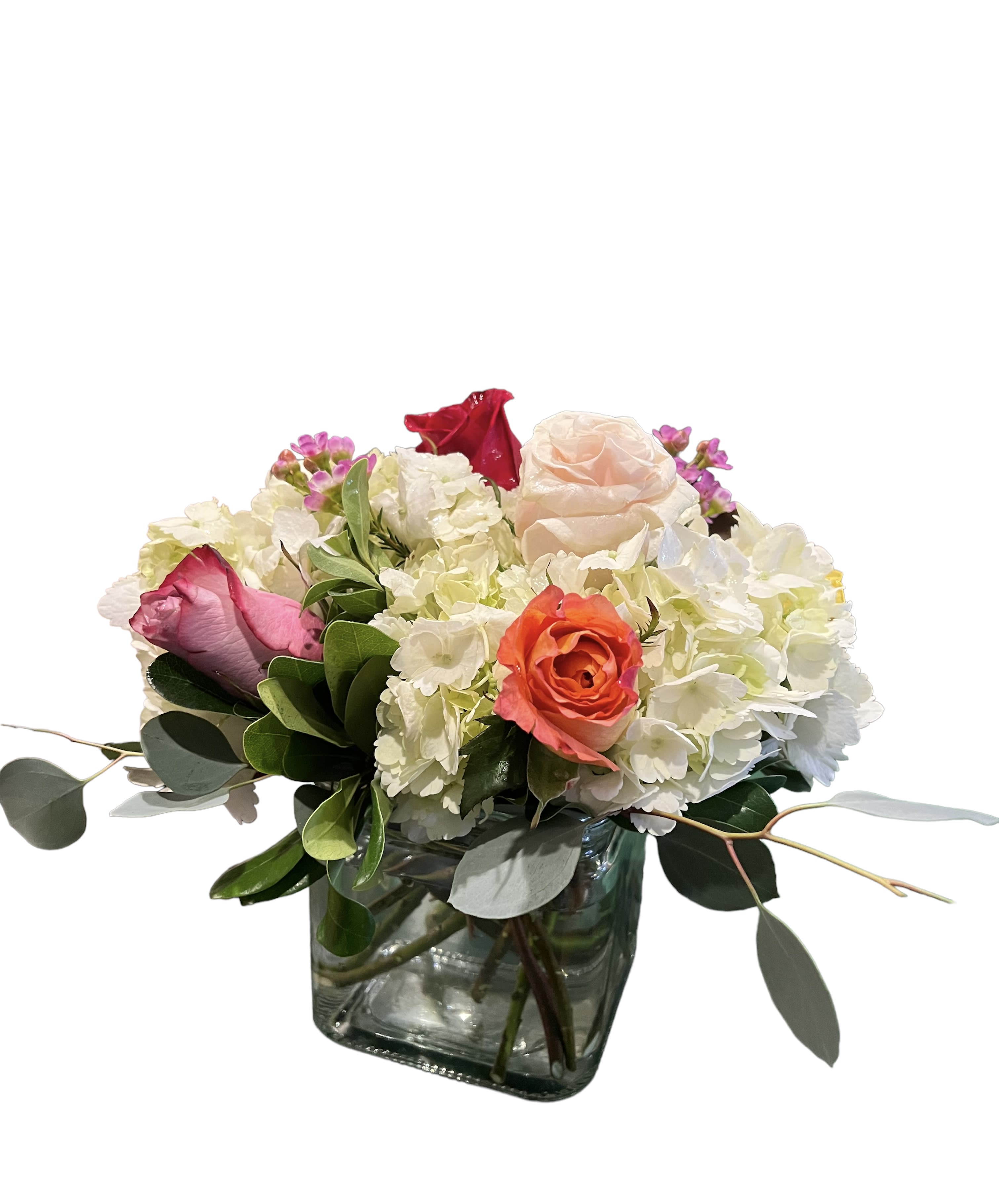 Mixed bouquet of roses and white hydrangeas in a glass vase