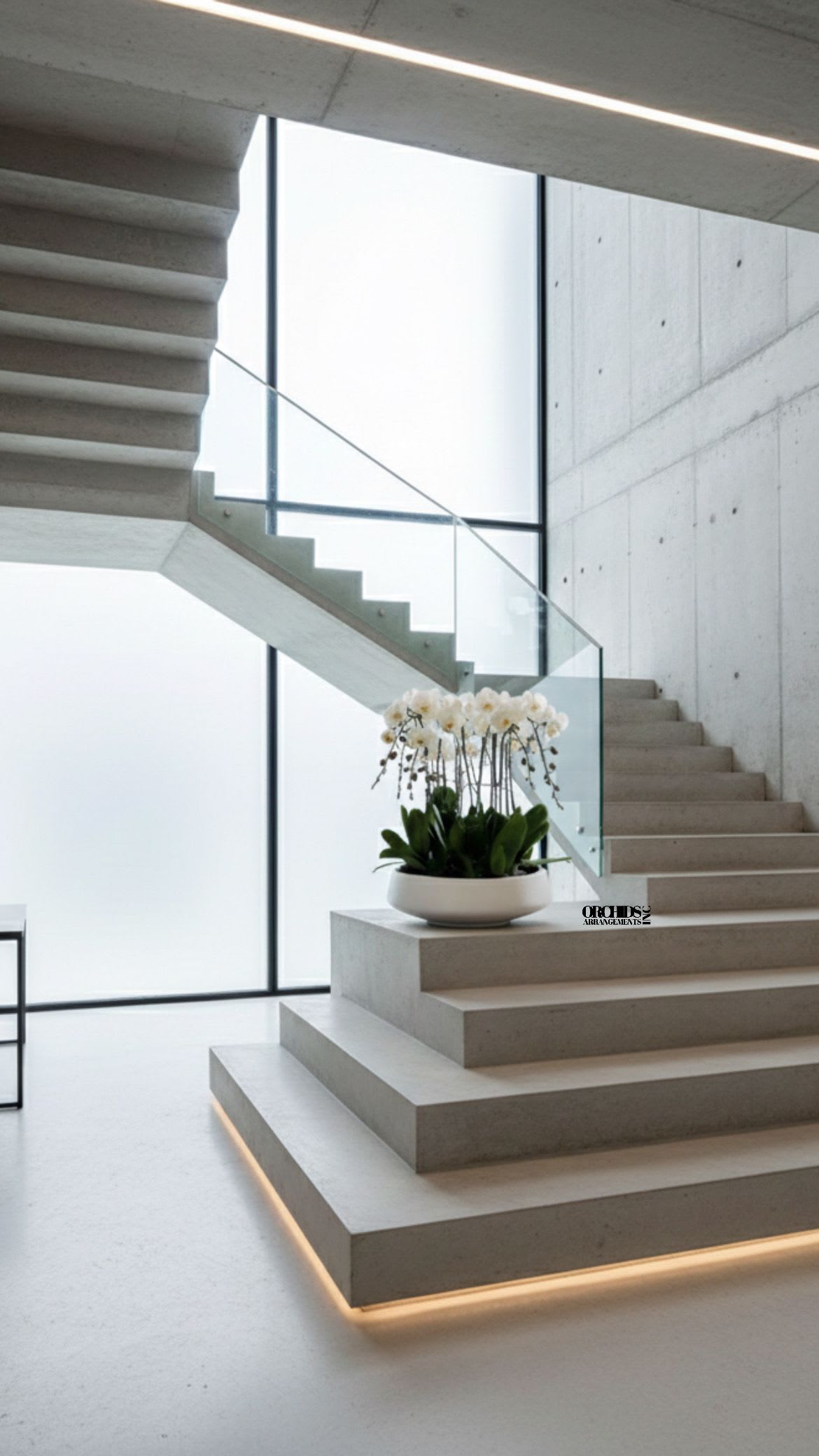 White orchid arrangement in a shallow white bowl on a staircase landing