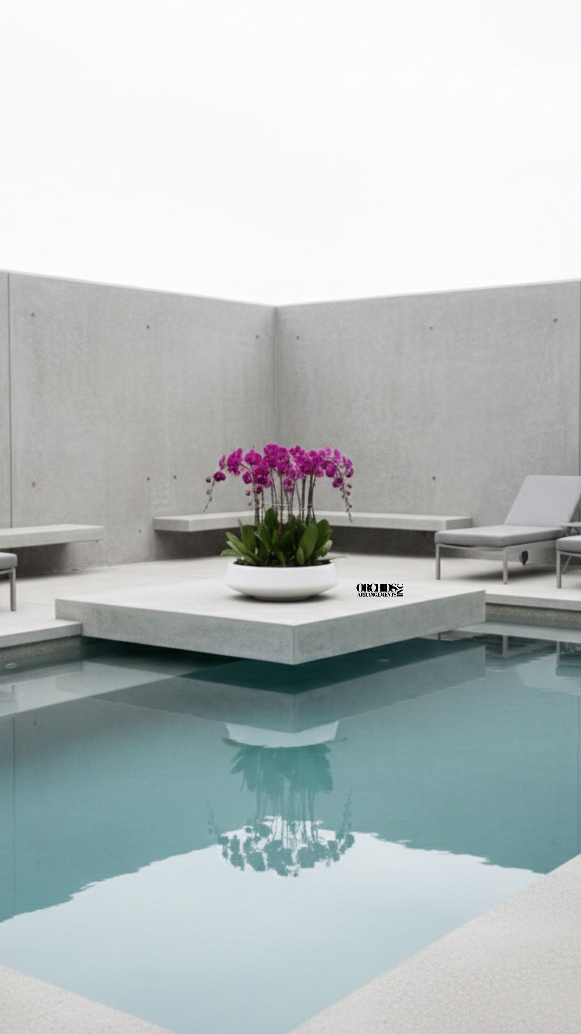 Pink orchid arrangement in a white bowl beside a pool