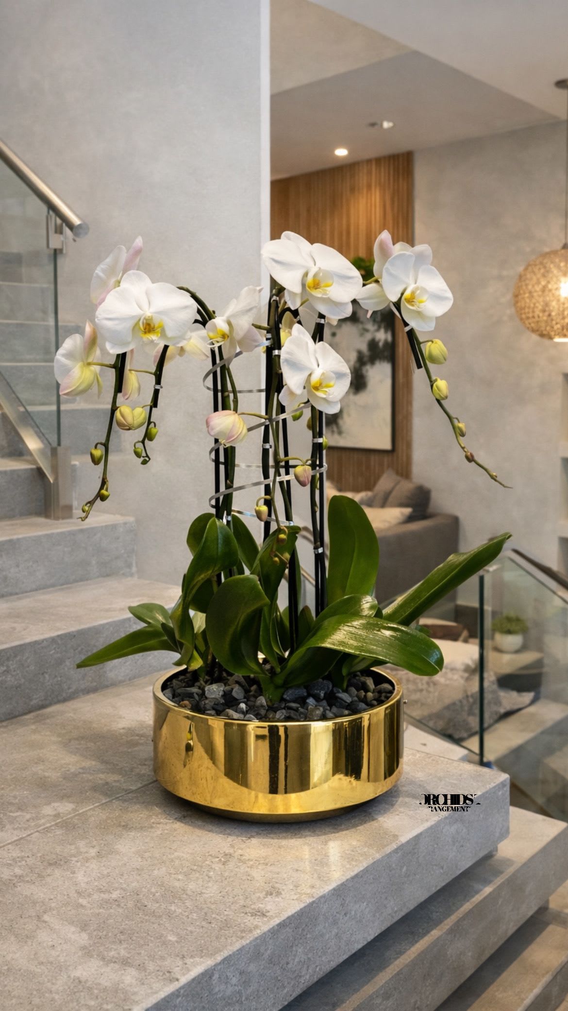 White orchids arranged in a gold planter on a staircase landing