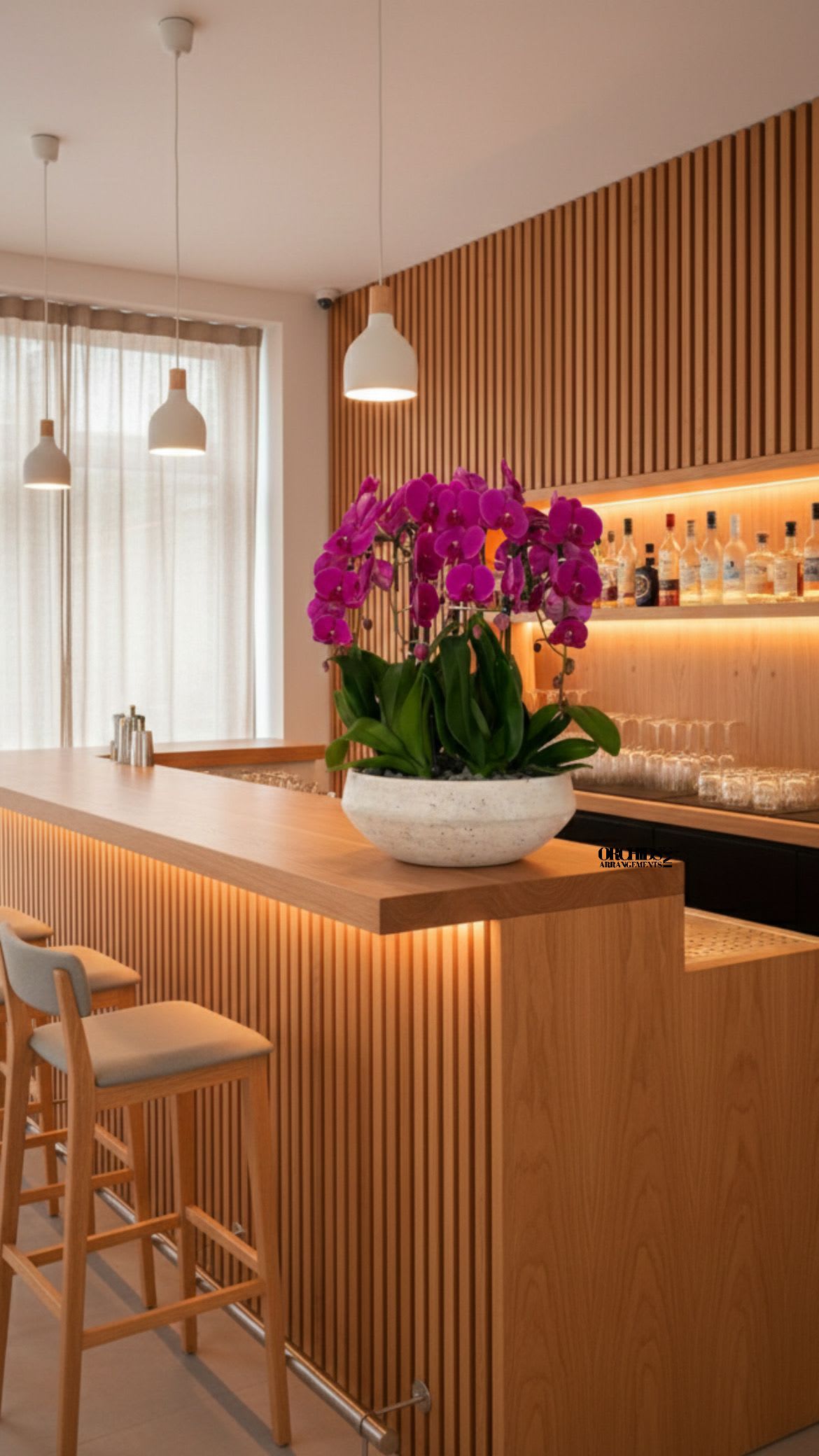 Potted purple orchids in a white bowl planter on a wooden counter