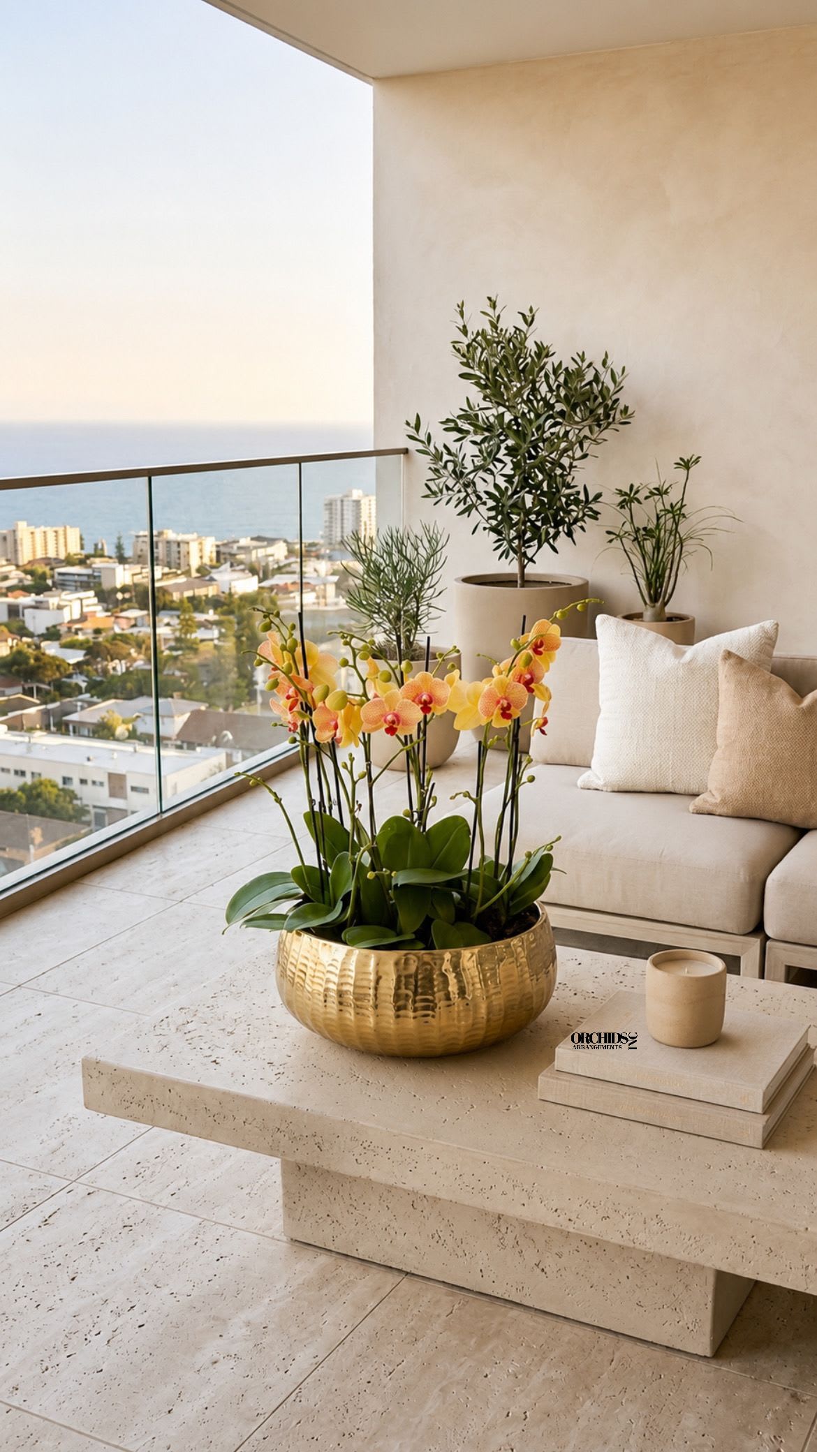 Potted yellow-orange orchids in a gold bowl on a patio table