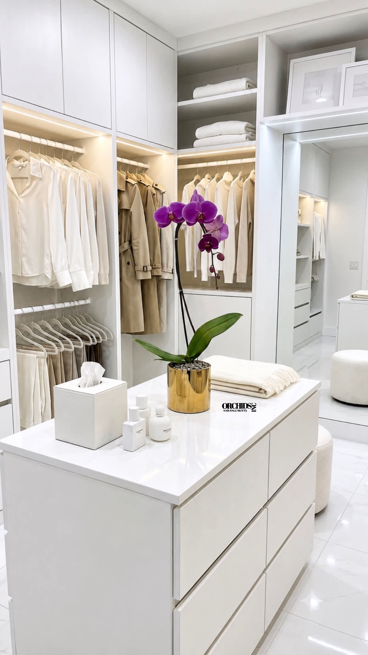 Purple orchid in a gold pot on a white island in a walk-in closet.