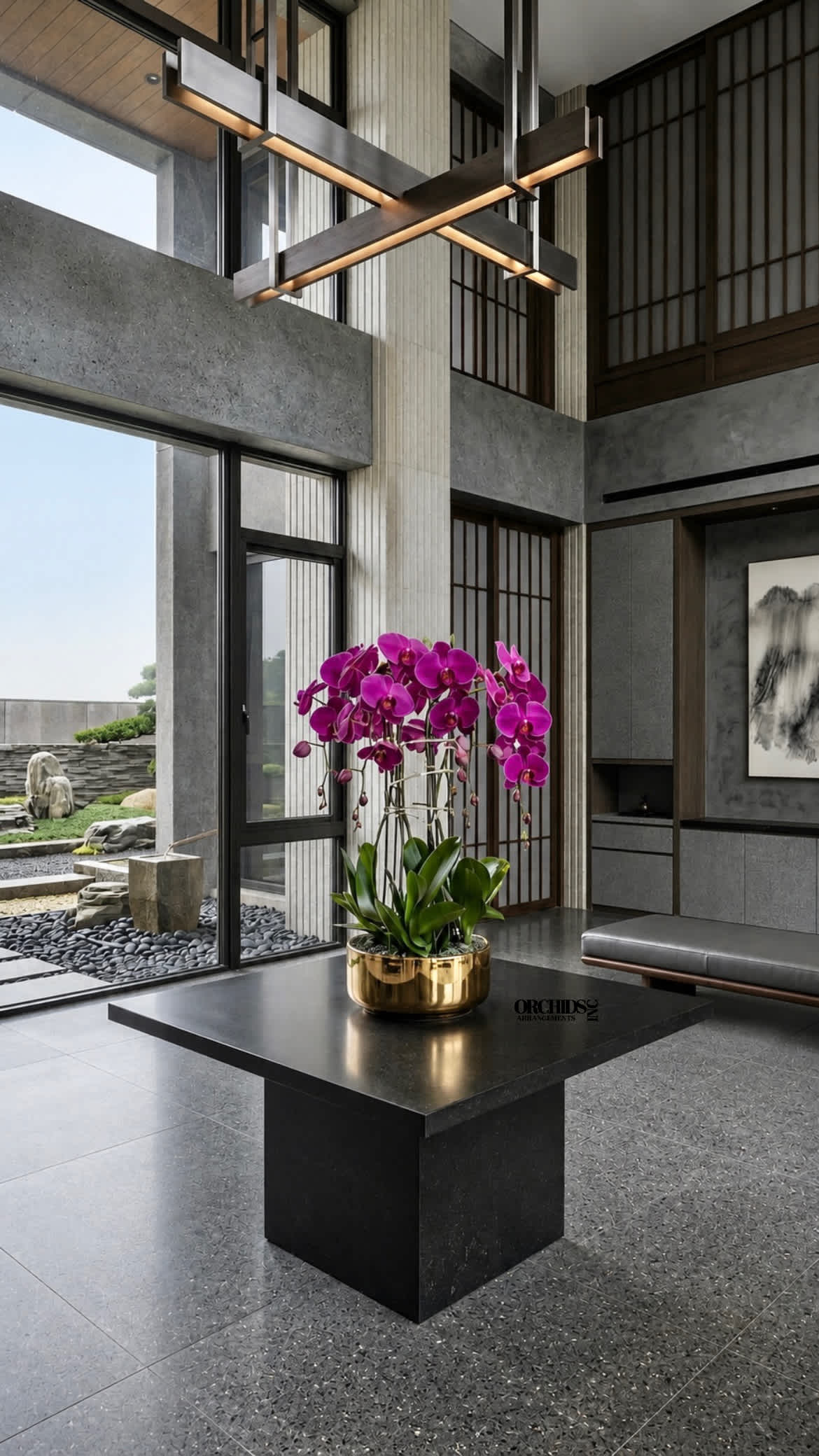 Potted purple orchids in a gold planter on a black table