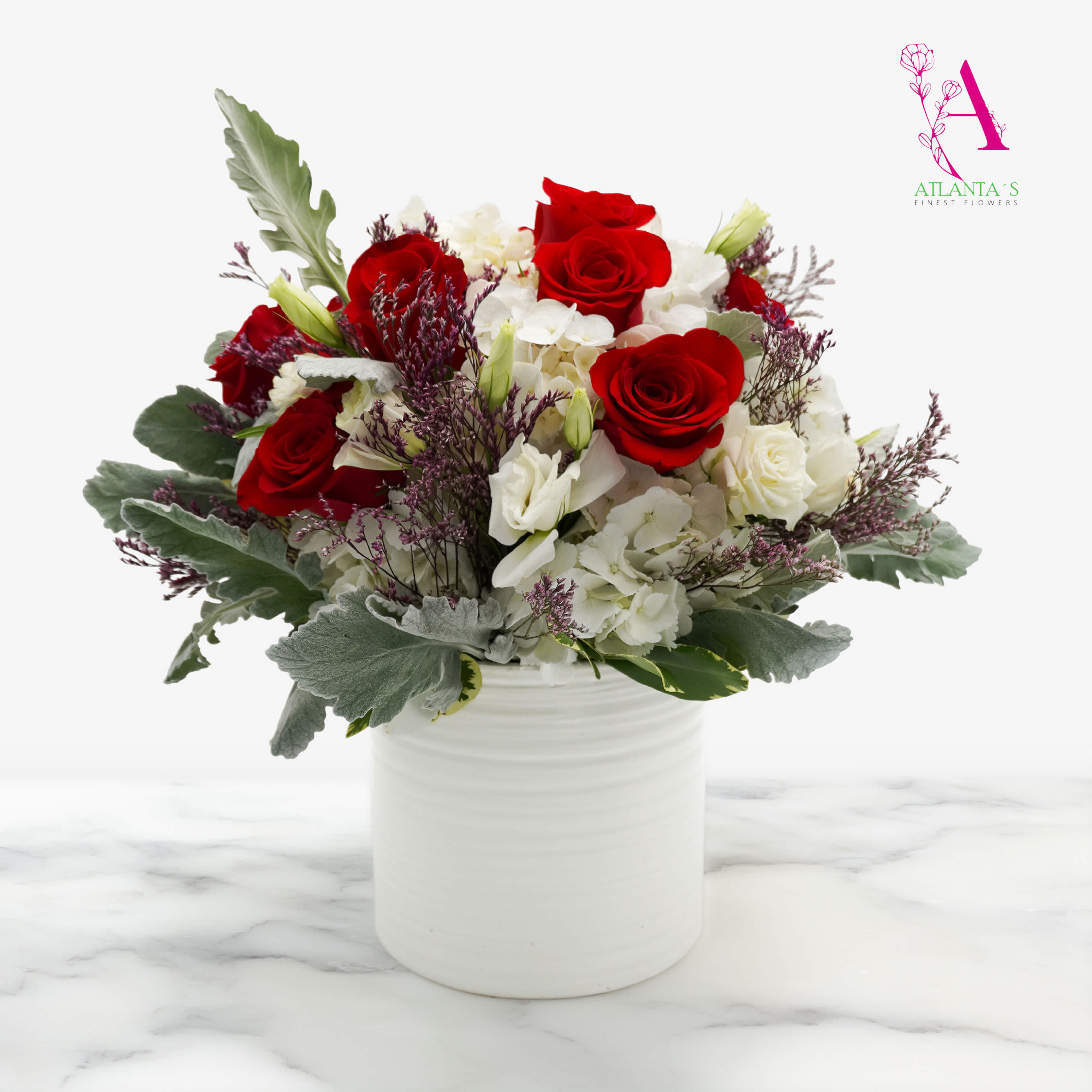 Red roses and white flowers arranged in a white vase