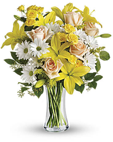 Yellow lilies and peach roses in a clear glass vase