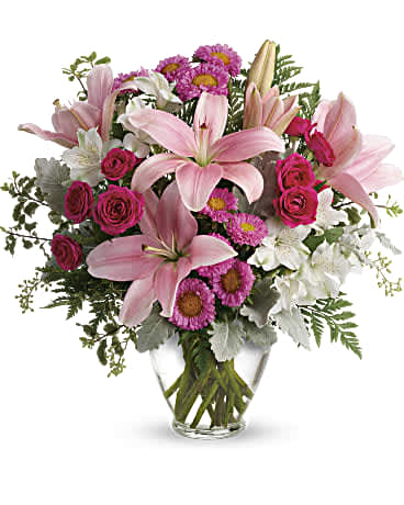 Pink lilies and roses in a clear glass vase