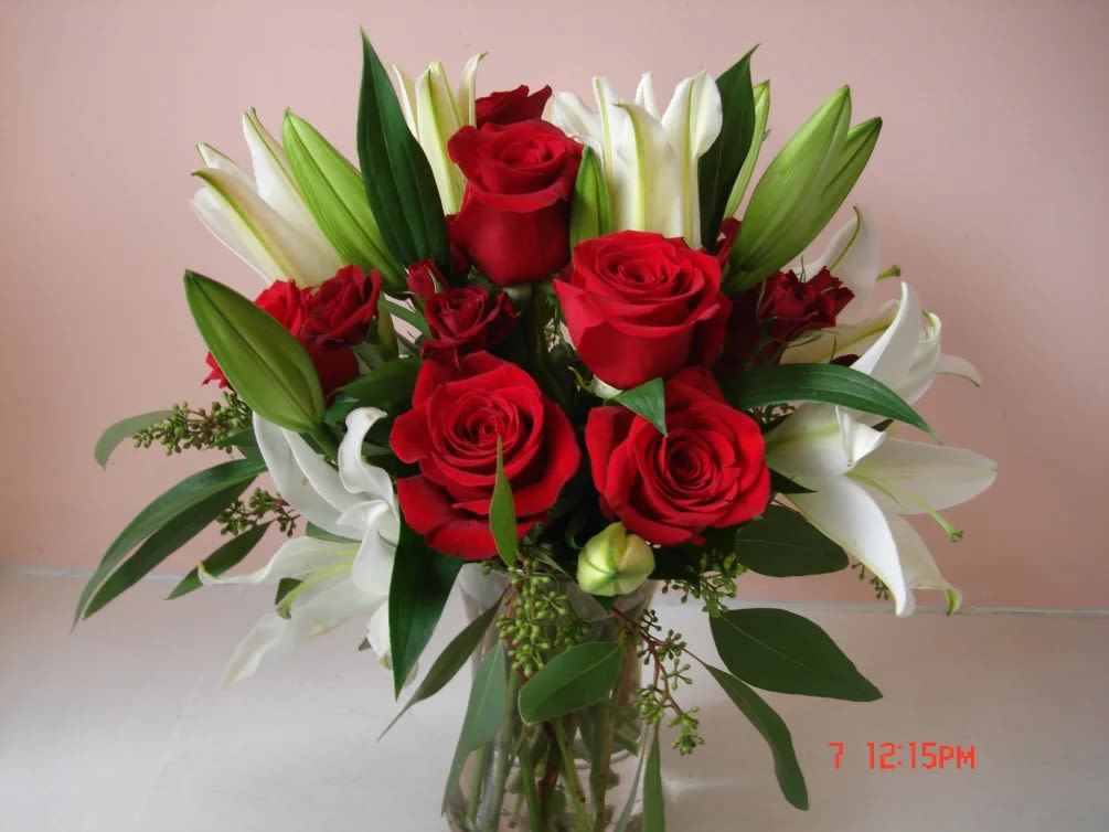 Bouquet of red roses and white lilies in a clear glass vase