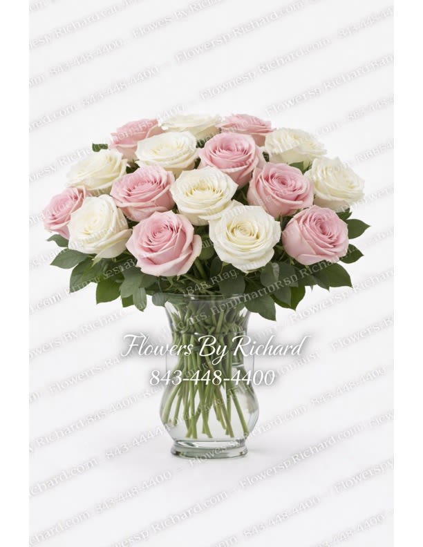 Pink and white roses arranged in a clear glass vase