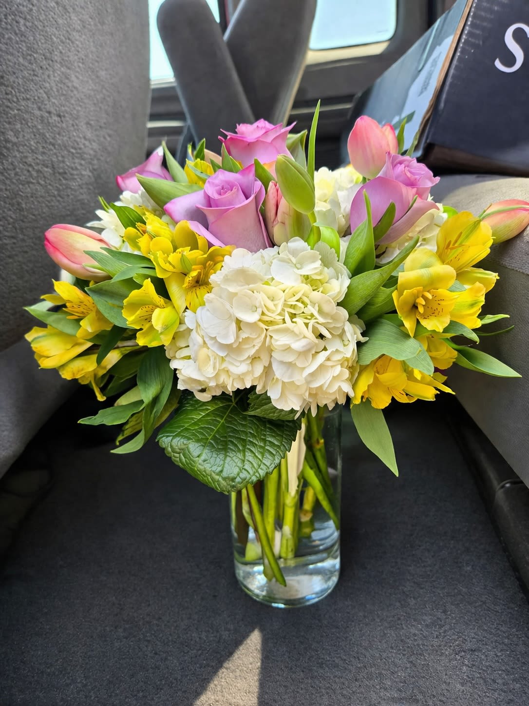 Blush Spring Garden Bouquet - A soft and uplifting blend of seasonal blooms, this arrangement features delicate pink roses, fresh tulips, creamy hydrangea, and vibrant yellow alstroemeria. Designed with a natural garden feel, it brings together warmth and elegance in a compact, hand-tied style. Perfect for celebrating life’s everyday moments, sending a thoughtful gesture, or brightening any space with fresh, cheerful beauty.