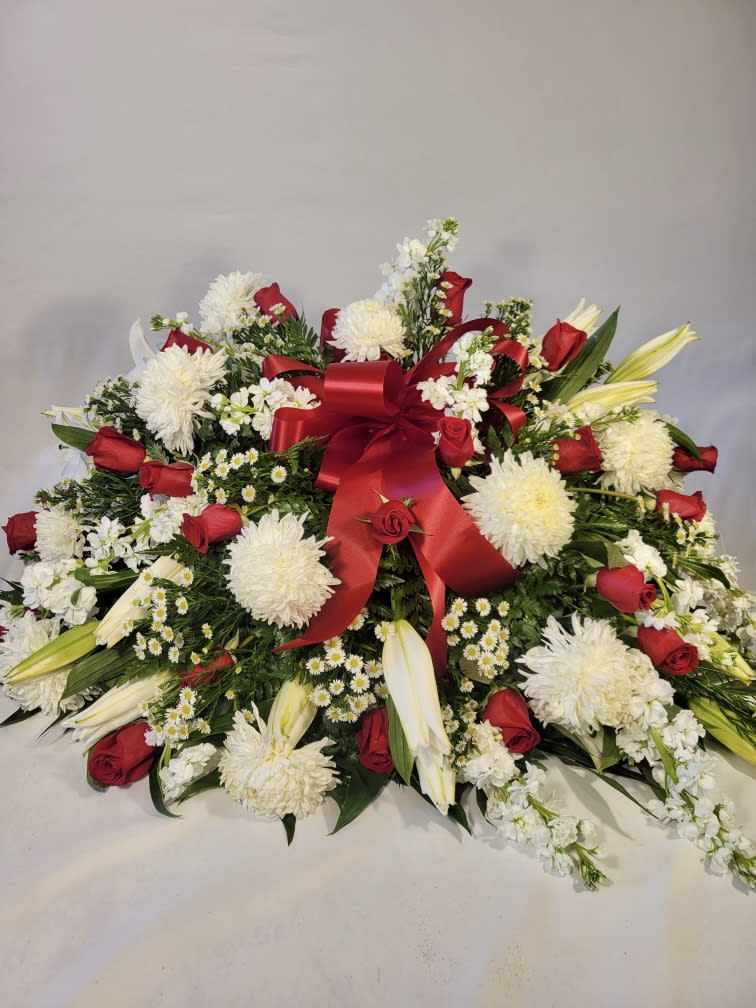 Large red, white, and yellow floral spray with a red ribbon bow