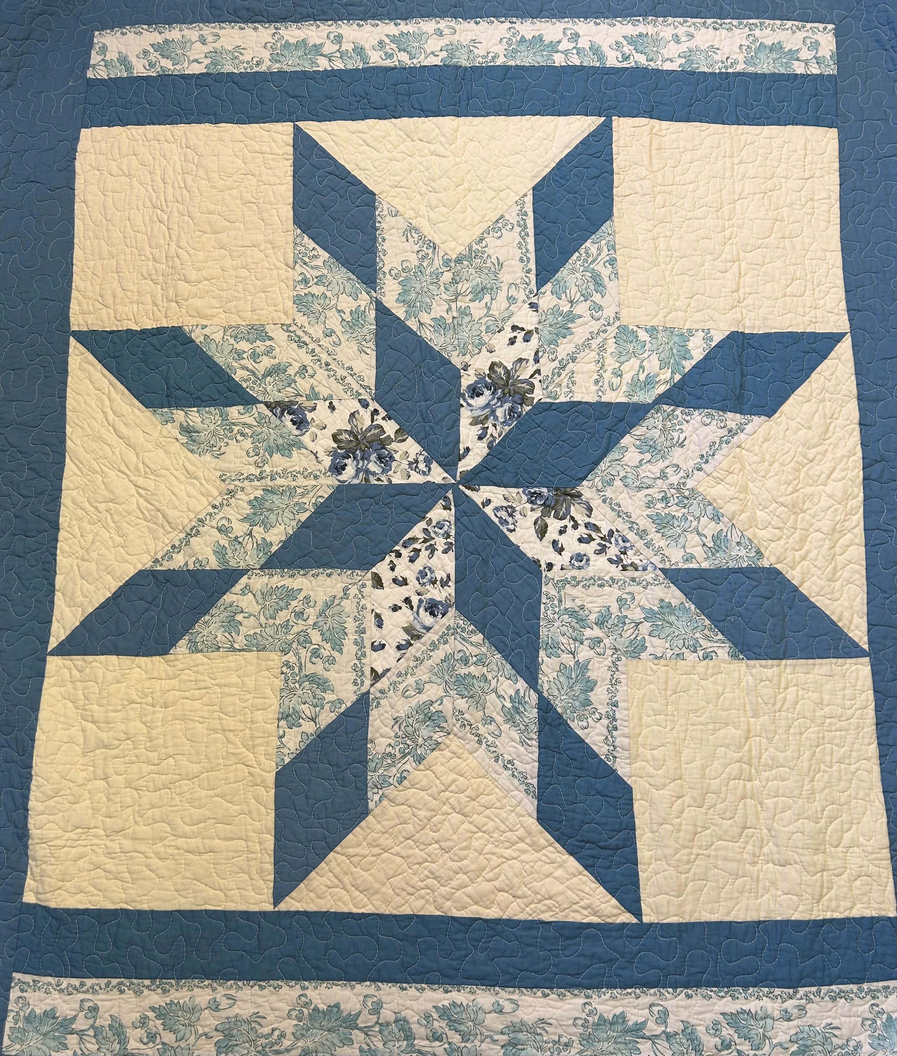 Blue and cream patchwork quilt with a star pattern
