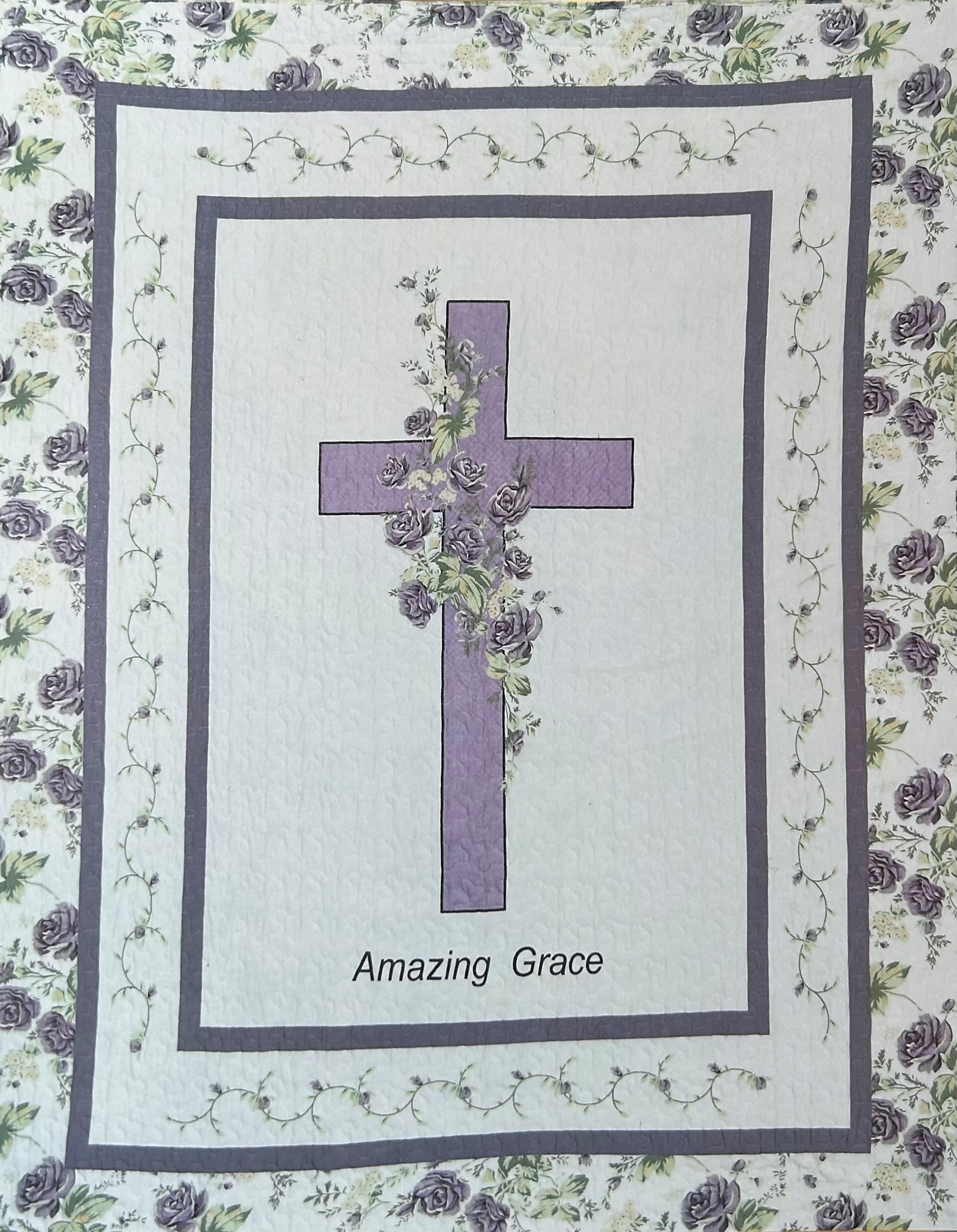 Quilt with a purple cross and floral border, labeled "Amazing Grace"